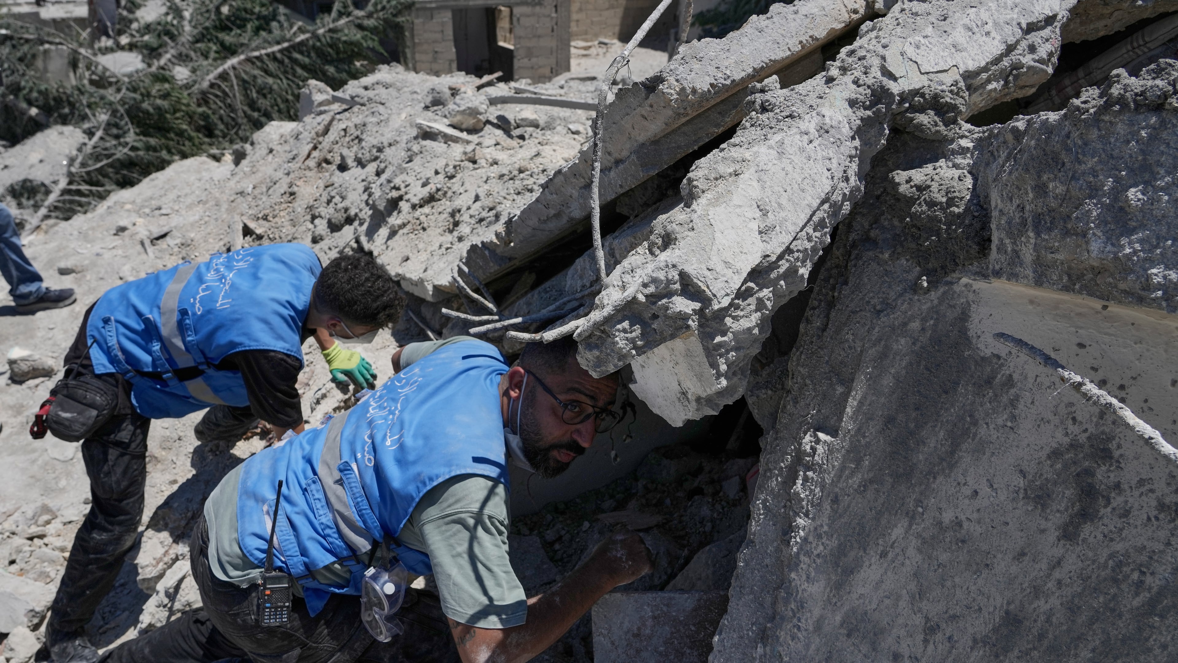 Rescue workers search for victims under the rubble of a destroyed building that was hit in an Israeli airstrike in Qannarit village, southern Lebanon, Saturday, June 20, 2026. (AP Photo/Mohammed Zaatari)