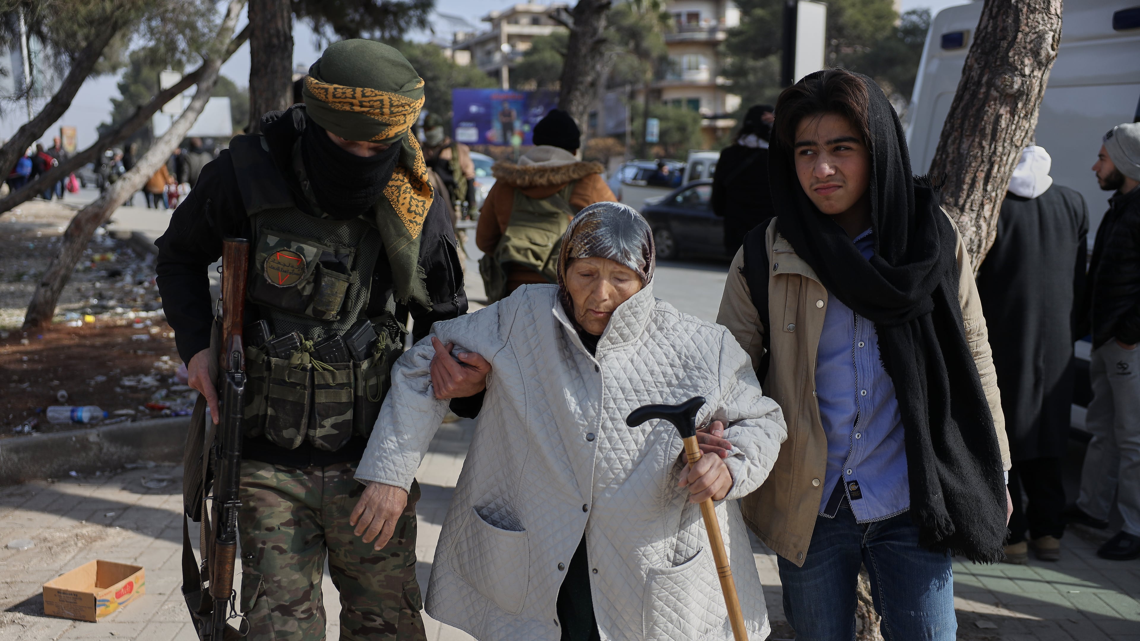 A Syrian government soldier helps an old woman who is fleeing from Sheikh Maqsoud and Achrafieh neighborhoods after clashes broke out on Tuesday between Syrian government forces and Kurdish fighters in a contested area of the northern city of Aleppo, Syria, Wednesday, Jan. 7, 2026. (AP Photo/Omar Albam)