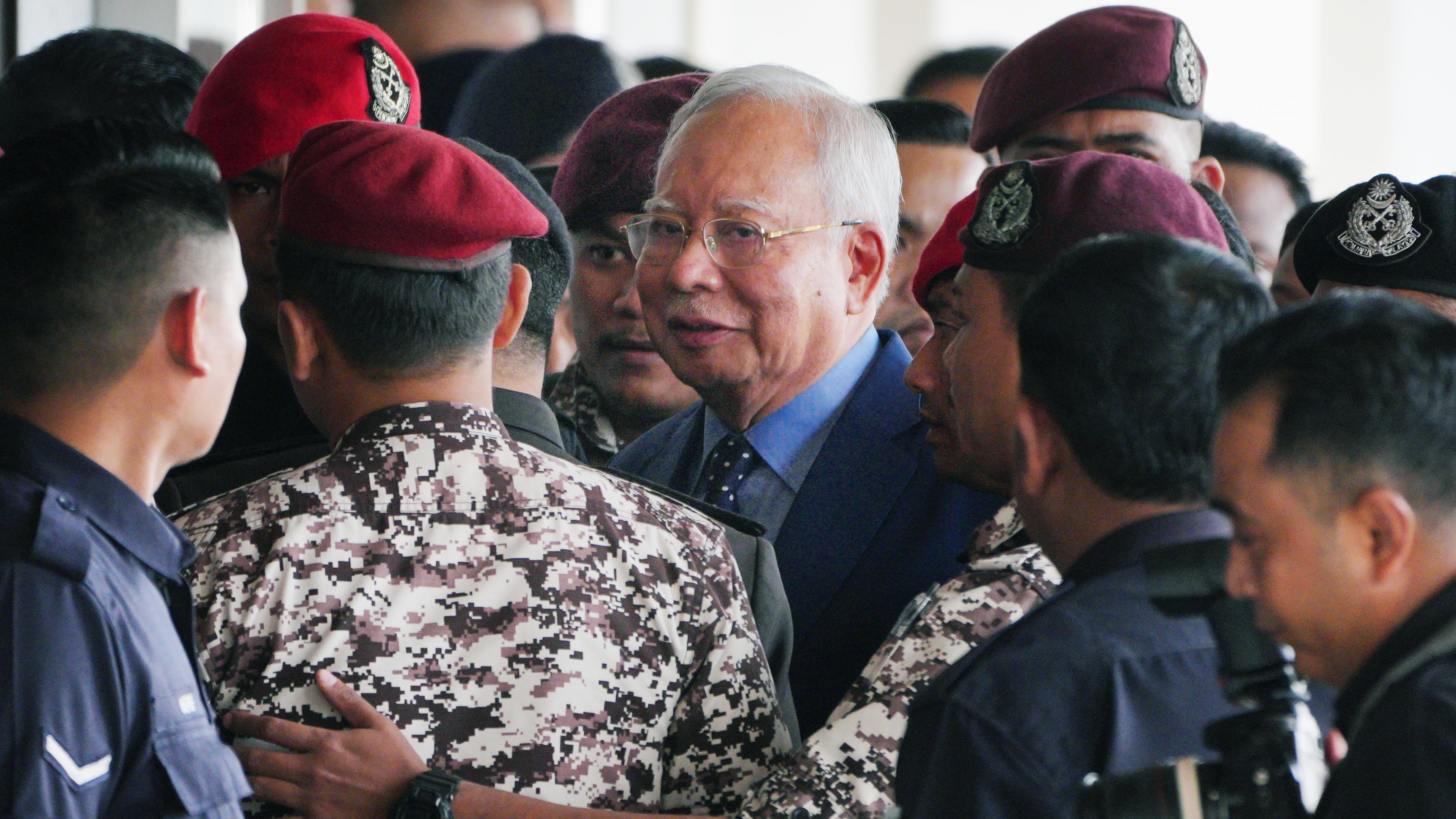 FILE - Malaysian former Prime Minister Najib Razak, center, is escorted by prison officers on his arrival at the Kuala Lumpur High Court complex in Kuala Lumpur, Malaysia, Oct. 30, 2024. (AP Photo/Vincent Thian, File)