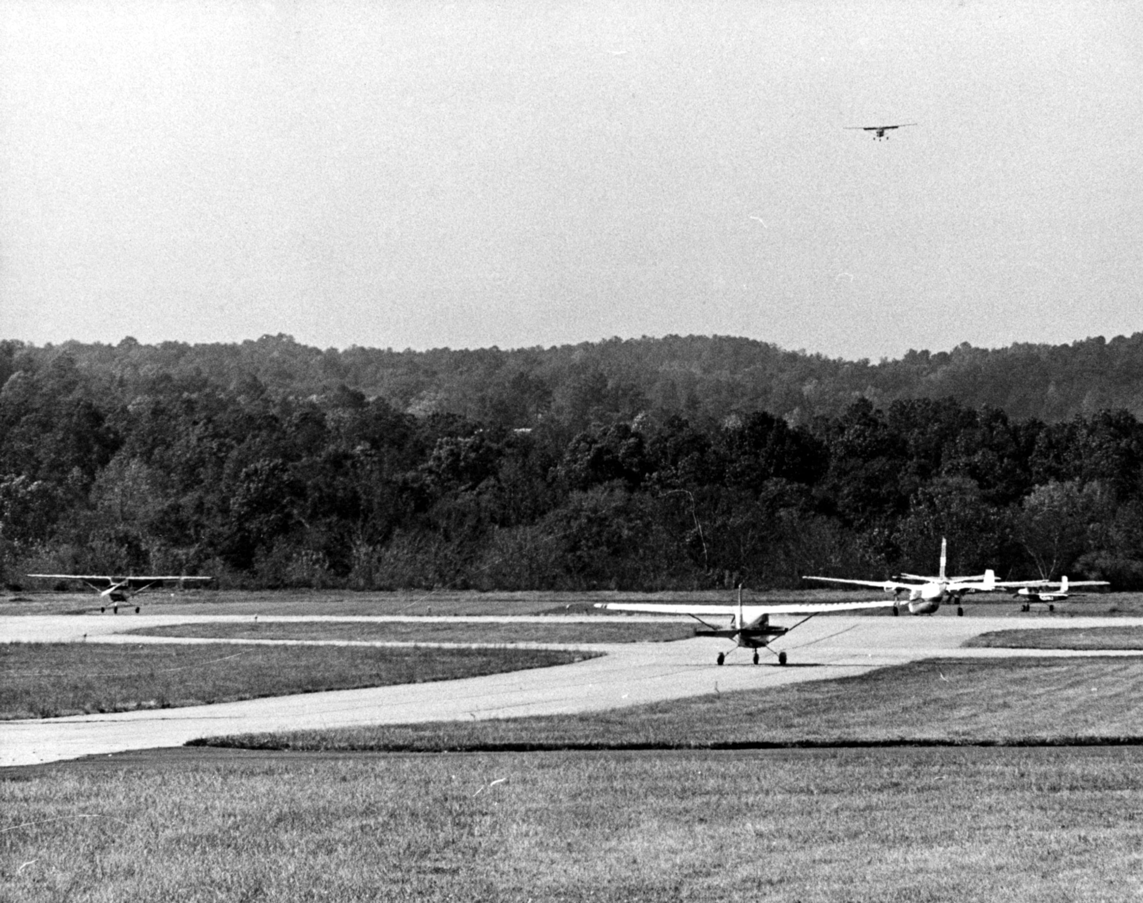 It's an airplane traffic jam at the Fulton County Airport on Oct. 29, 1967. There's one landing on runway, another approaching still airborne, and three waiting at end of runway to take off. Robert Connell/AJC