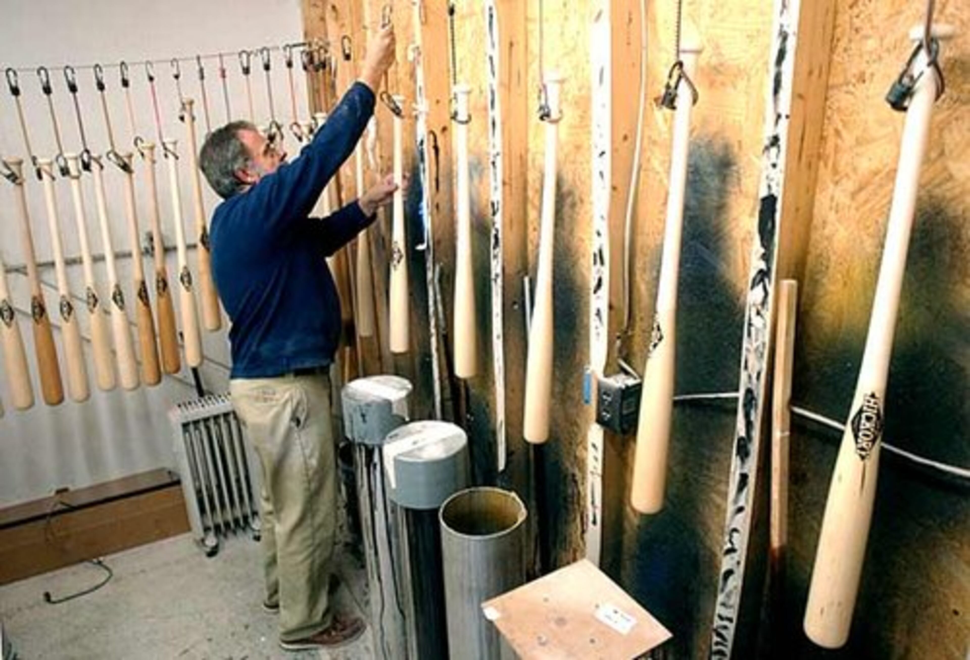 Old HIckory co-owner Jon Moyer hangs up a freshly-coated baseball bat to dry. Some players believe the ball comes off the bat better with maple, though a study at the University of Massachusetts-Lowell showed the ball carried no better off maple than ash.
