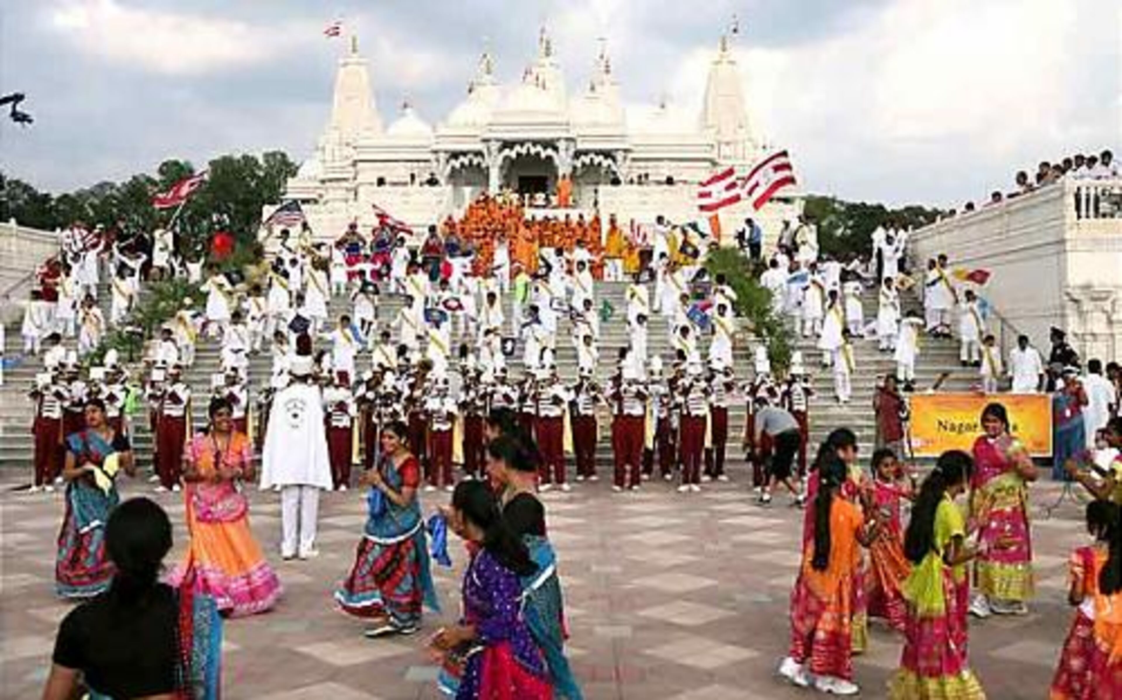 Visitors to the new Hindu temple in Lilburn celebrate during the grand procession along Lawrenceville Highway on Saturday. In the last three weeks, more than 900 volunteers have worked virtually around the clock tending to last minute details before the temple's consecration.