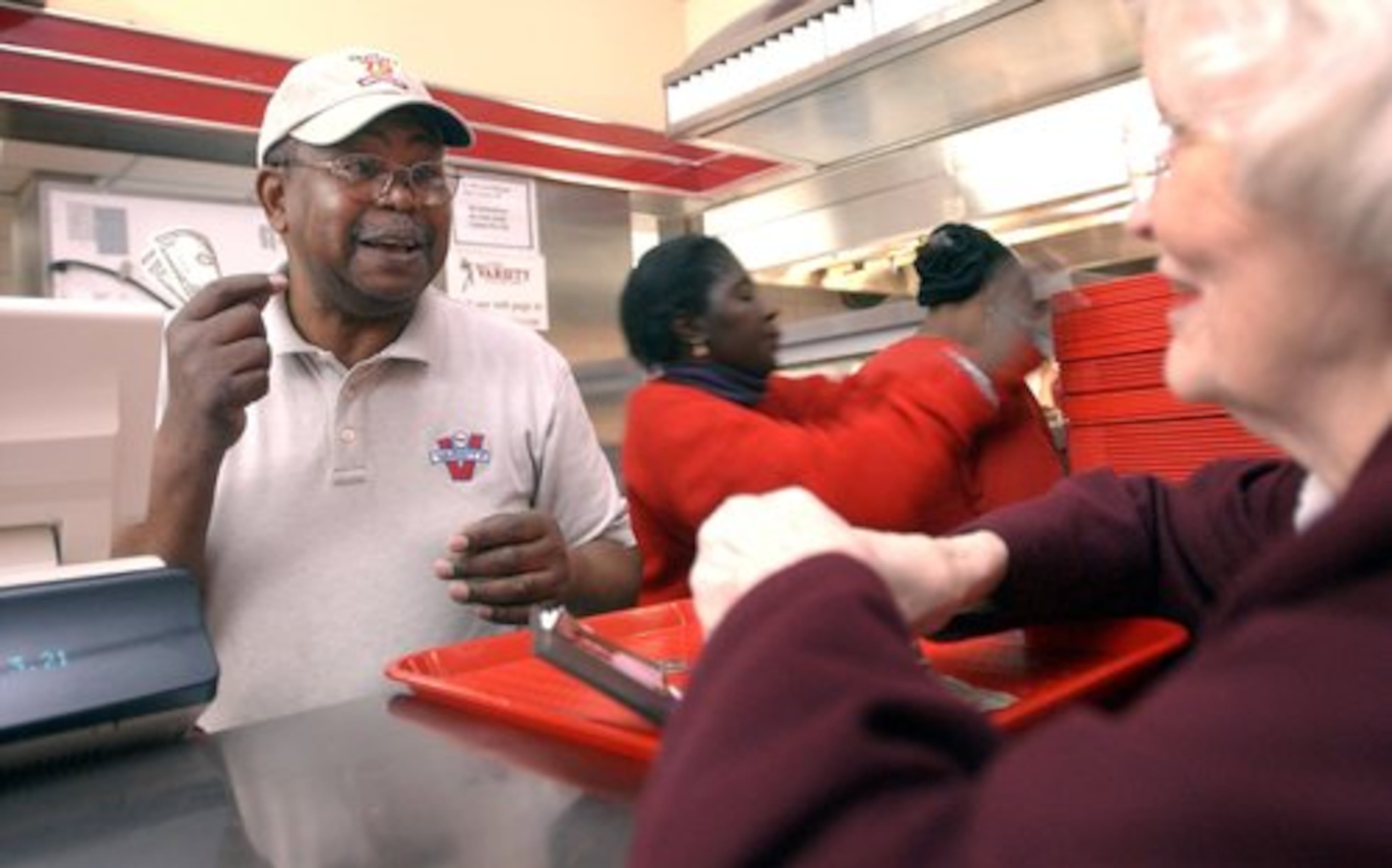 Erby Walker, the speedy Varsity counterman who served generations of Atlantans and celebrity visitors, has died. He had retired from the restaurant in 2003 after 51 years, but kept coming back to work the counter. In 2003 he chatted with customer Emma Campbell (right). 'I've known him all these years he's been here, ' she said.