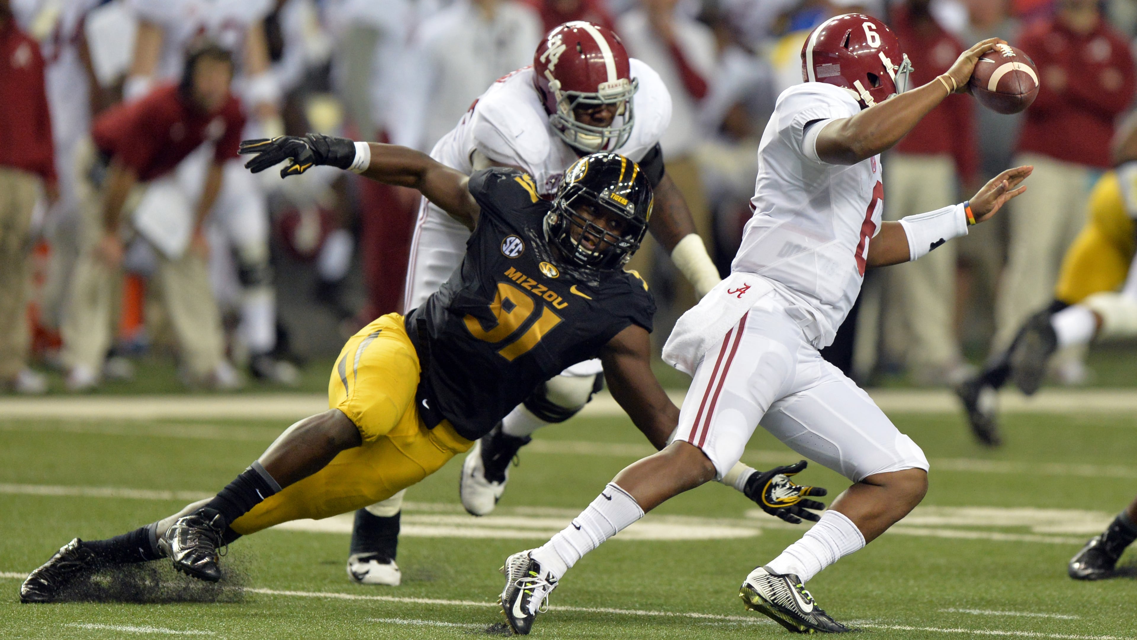 December 6, 2014 Atlanta:Alabama Crimson Tide quarterback Blake Sims scrambles to elude the tackle of Missouri Tigers defensive lineman Charles Harris during the 2014 SEC Championship at the Georgia Dome Saturday December 6, 2014. BRANT SANDERLIN / BSANDERLIN@AJC.COM