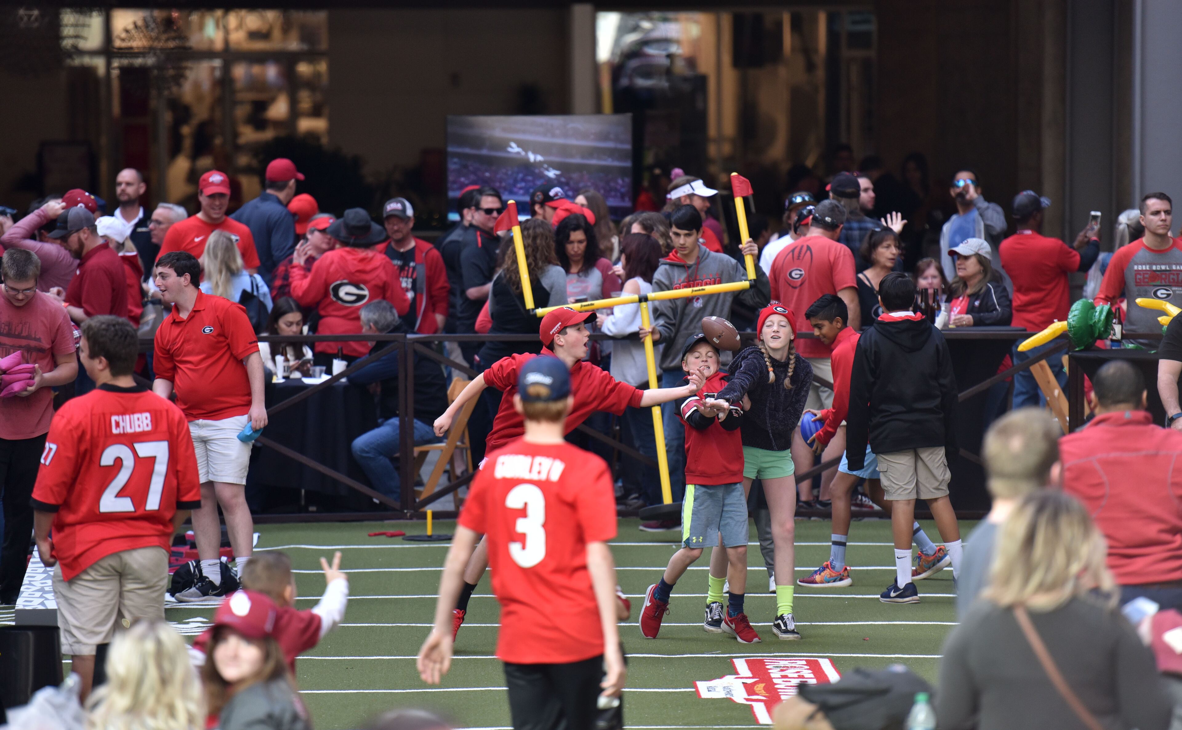 December 31, 2017 Los Angeles, California - Connor Flagel (center), of Marietta, plays a game of corn hole during the Rose Bowl Bash in downtown Los Angeles on Sunday, December 31, 2017. Hyosub Shin / hshin@ajc.com
