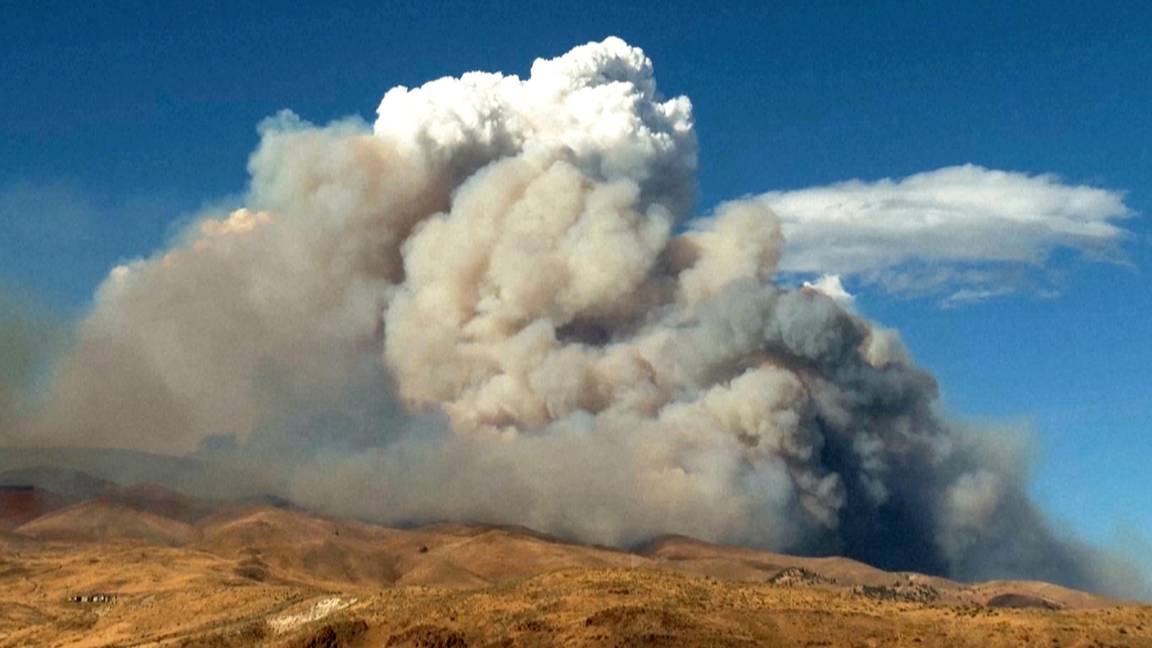 This image taken from video shows plumes of smoke rising from active wildfires Saturday, Aug. 22, 2026, in Reno, Nevada. (Tim Walton via AP)