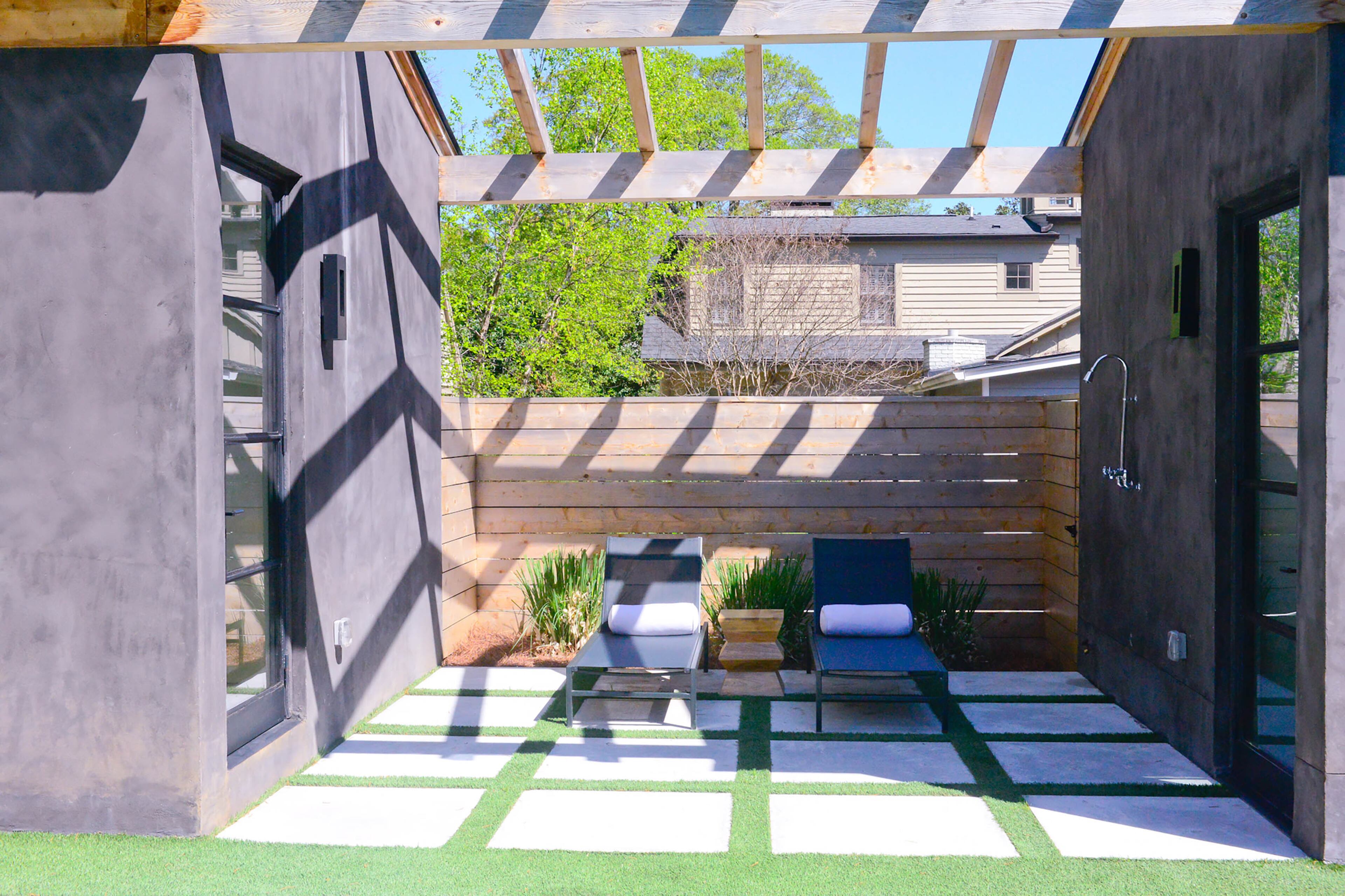 When they designed their backyard pool, Caroline and Paul Normark included a poolside nook with lounge chairs and an outdoor shower. Pavers sandwiched by grass soften the look and give the lounge area an organic feel.