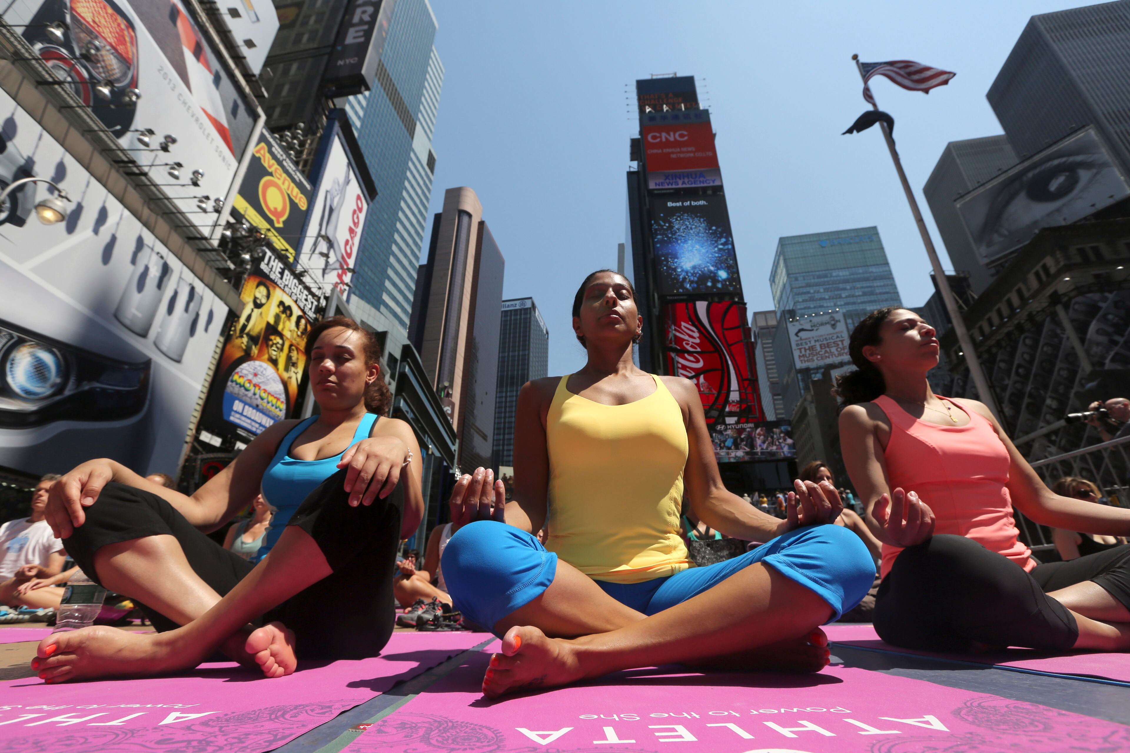 People practice yoga in New York's Times Square, Friday, June 21, 2013. Yoga enthusiasts marked the longest day of the year with five free "Mind Over Madness" yoga classes in Times Square. (AP Photo/Mary Altaffer)