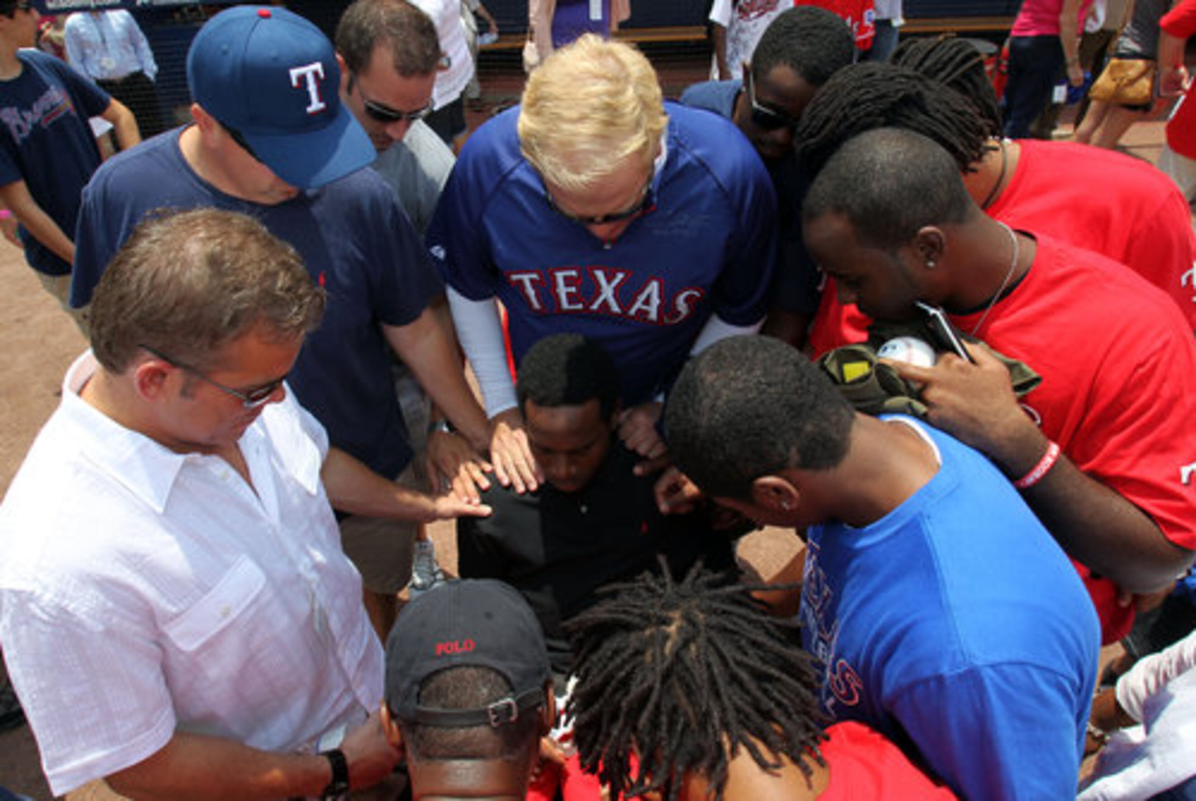 Jim Branch, top center, a family friend of Texas Rangers outfielder Josh Hamilton leads a prayer for Johnathan Taylor before the Rangers game against the Atlanta Braves at Turner Field on Saturday afternoon.