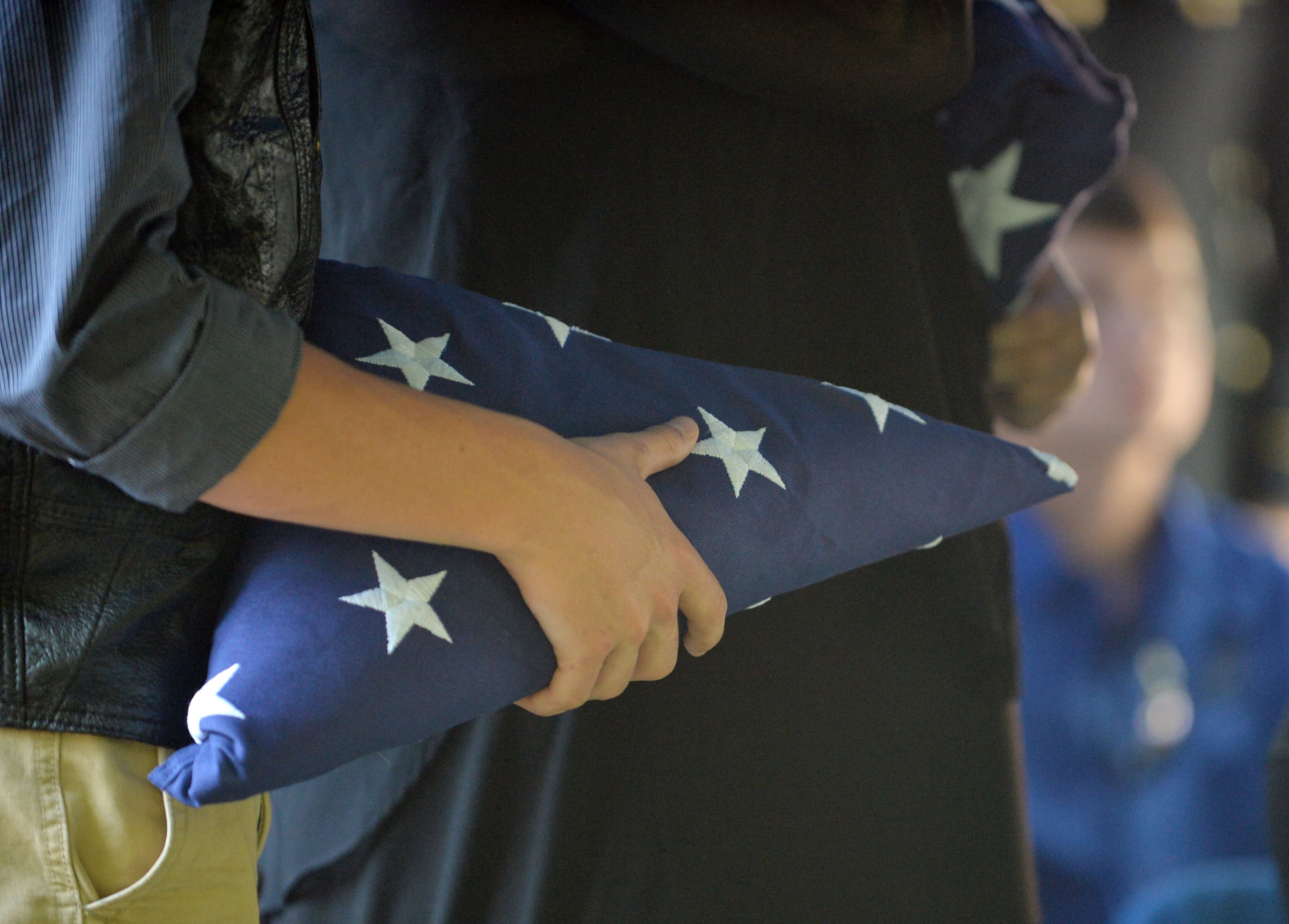 Zachary Hawks holds his father's flag following the ceremony at the A.E. Carter Funeral Home in Madison, Ga.