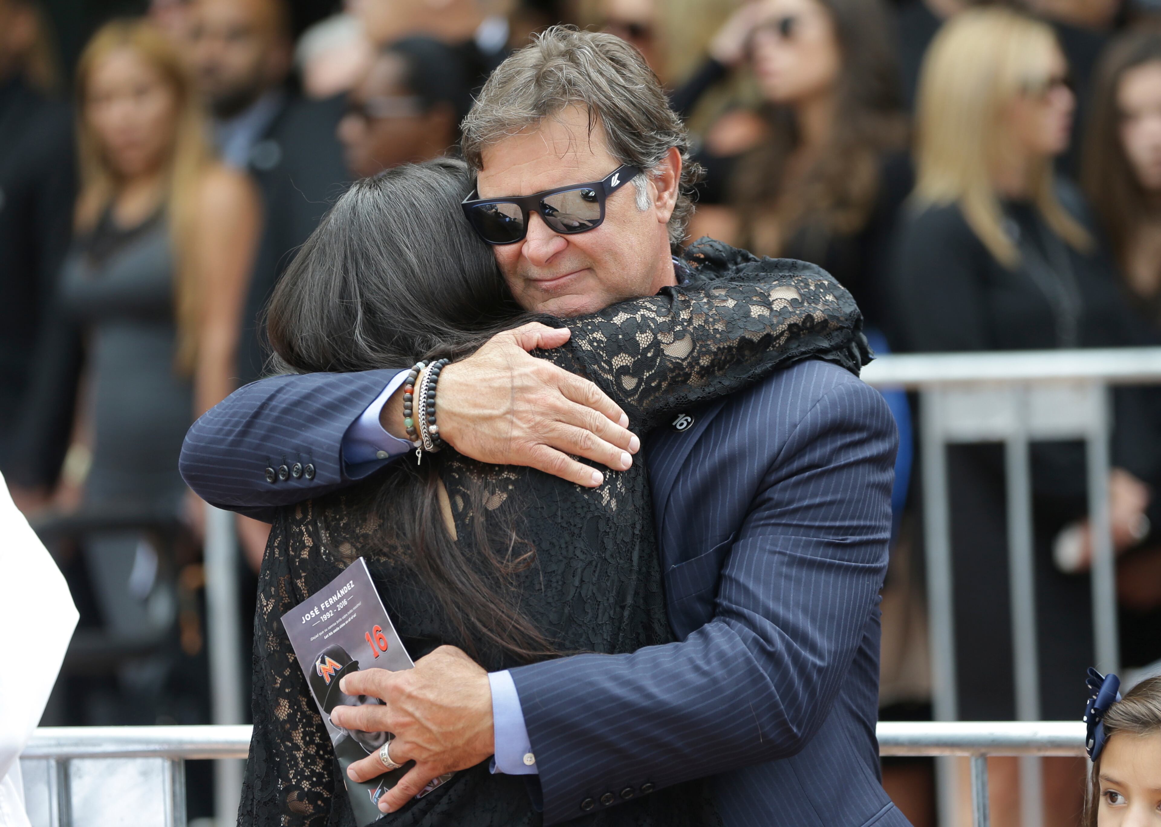 Miami Marlins manager Don Mattingly, right, hugs Maria Arias, the girlfriend of Miami Marlins pitcher Jose Fernandez, left, after a memorial service for Fernandez at St. Brendan's Catholic Church, Thursday, Sept. 29, 2016, in Miami. Fernandez was killed in a boating accident Sunday along with two friends. (AP Photo/Lynne Sladky)