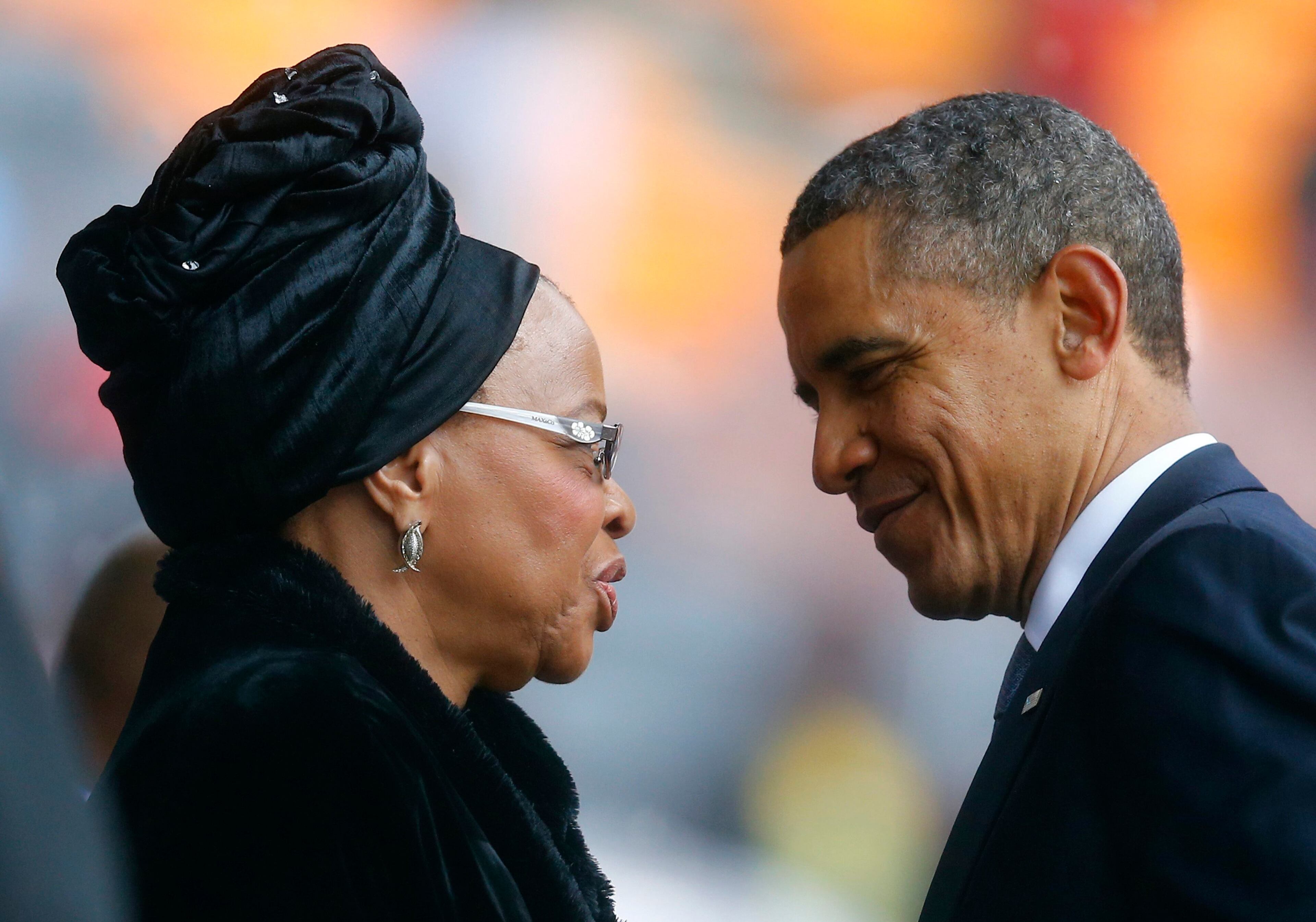 U.S. President Barack Obama pays his respect to Mandela's widow Graca Machel after his speech at the memorial service for late South African President Nelson Mandela at the FNB soccer stadium in Johannesburg December 10, 2013. World leaders, from U.S. President Barack Obama to Cuba's Raul Castro, will pay homage to Mandela at the memorial that will recall his gift for bringing enemies together across political and racial divides. REUTERS/Kai Pfaffenbach
