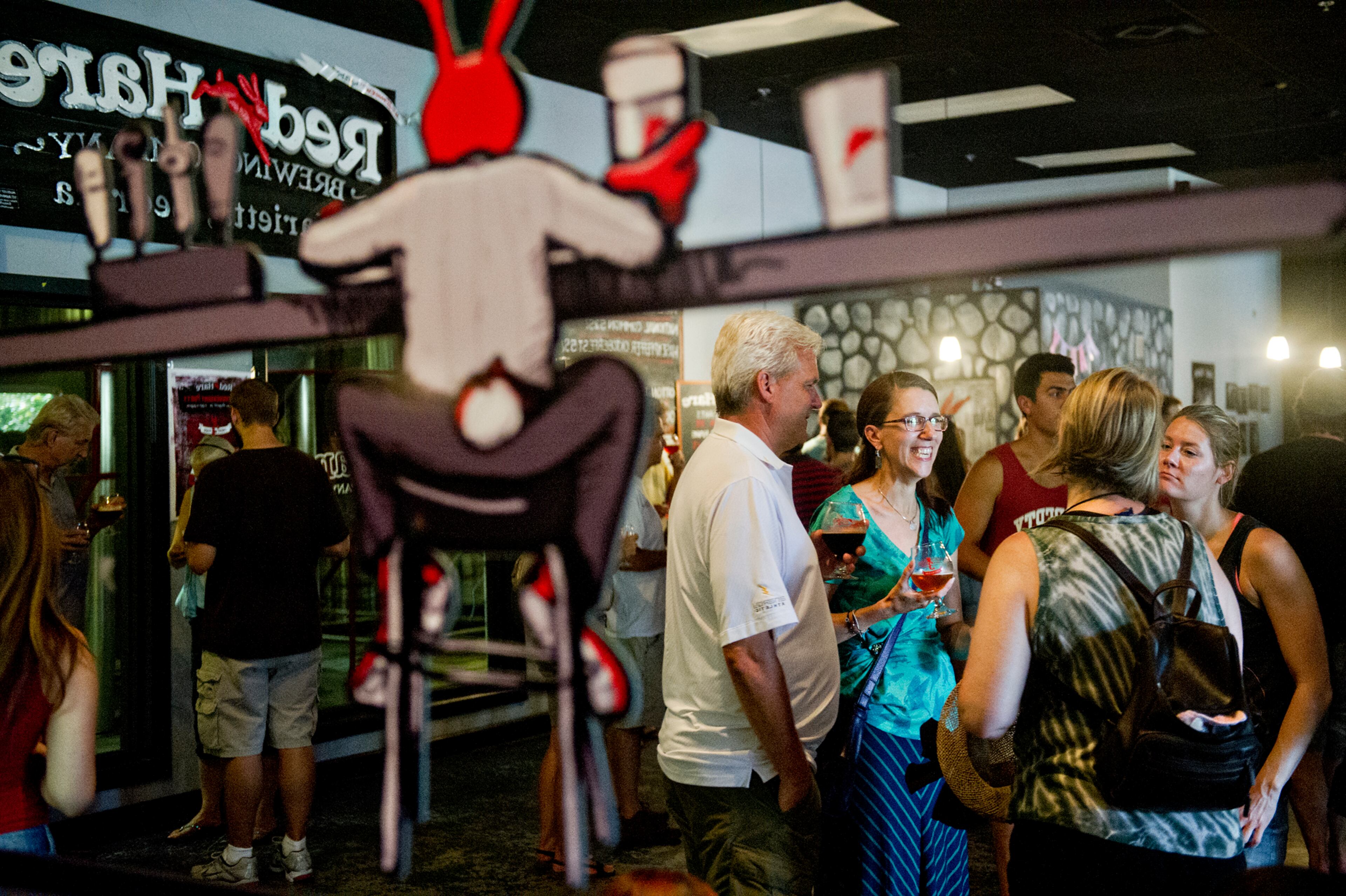Andy Tubbs (left), Elizabeth Landt, Abby Lund and Shari Eposito talk as they try different beers at Red Hare Brewery in Marietta during the company's third anniversary party on Saturday, August 23, 2014. Hundreds of people turned out for the celebration which included tastings, tours and live music. JONATHAN PHILLIPS / SPECIAL