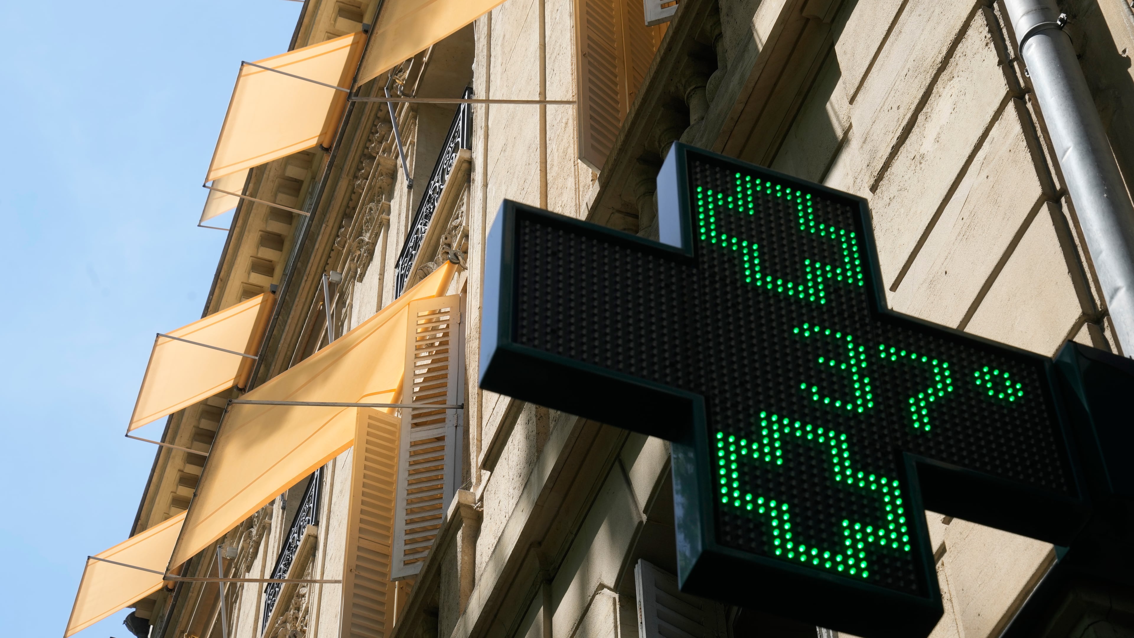 A sign outside a pharmacy displays a temperature of 37 degrees Celsius (98.6 degrees Fahrenheit) in Paris, Sunday, June 21, 2026. (AP Photo/Michel Euler)