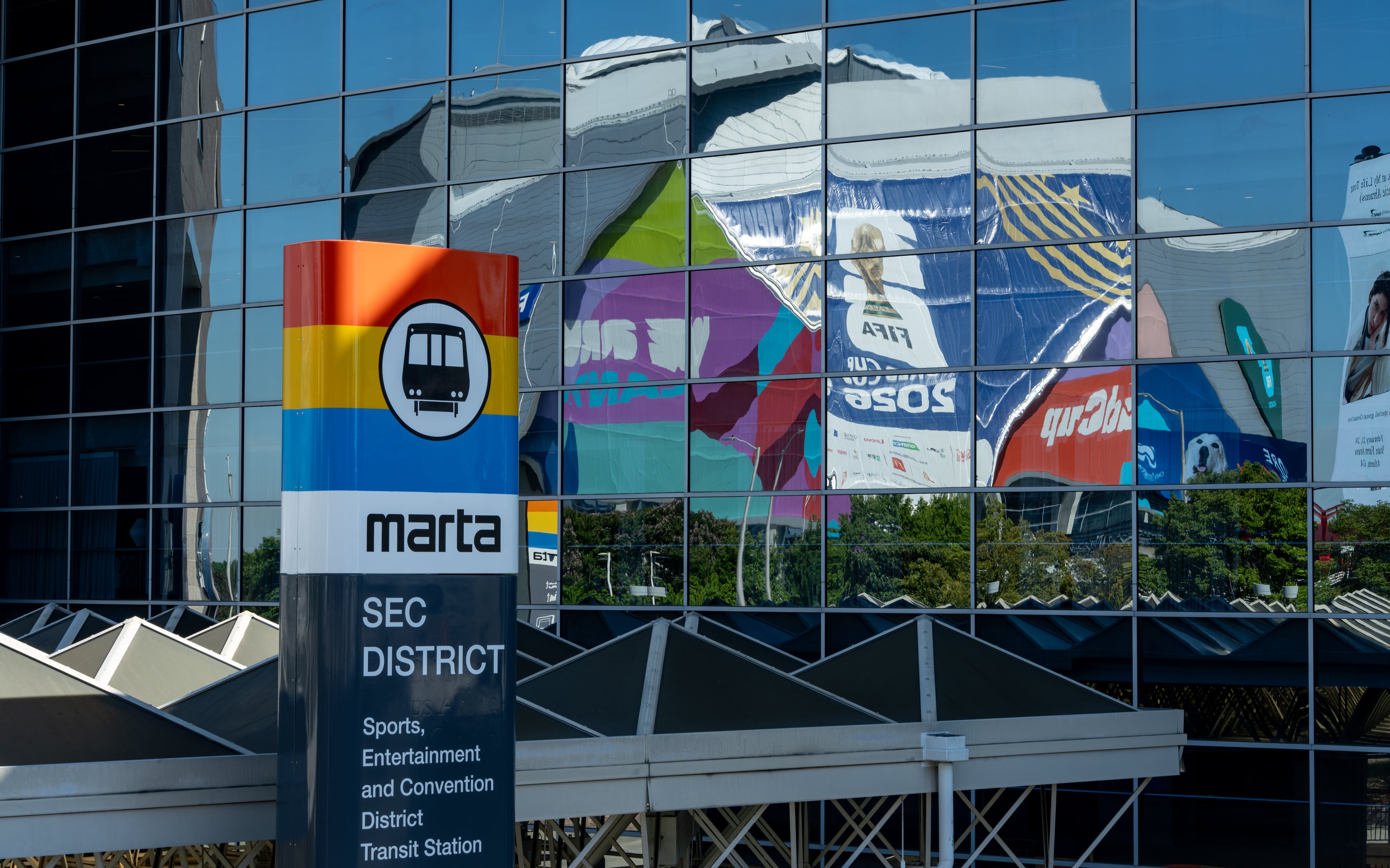 The Mercedes-Benz Statidum (Atlanta Stadium during the World Cup) is reflected in glass outside the SEC District MARTA station on Thursday, June 4, 2026. (Ben Hendren for the AJC)