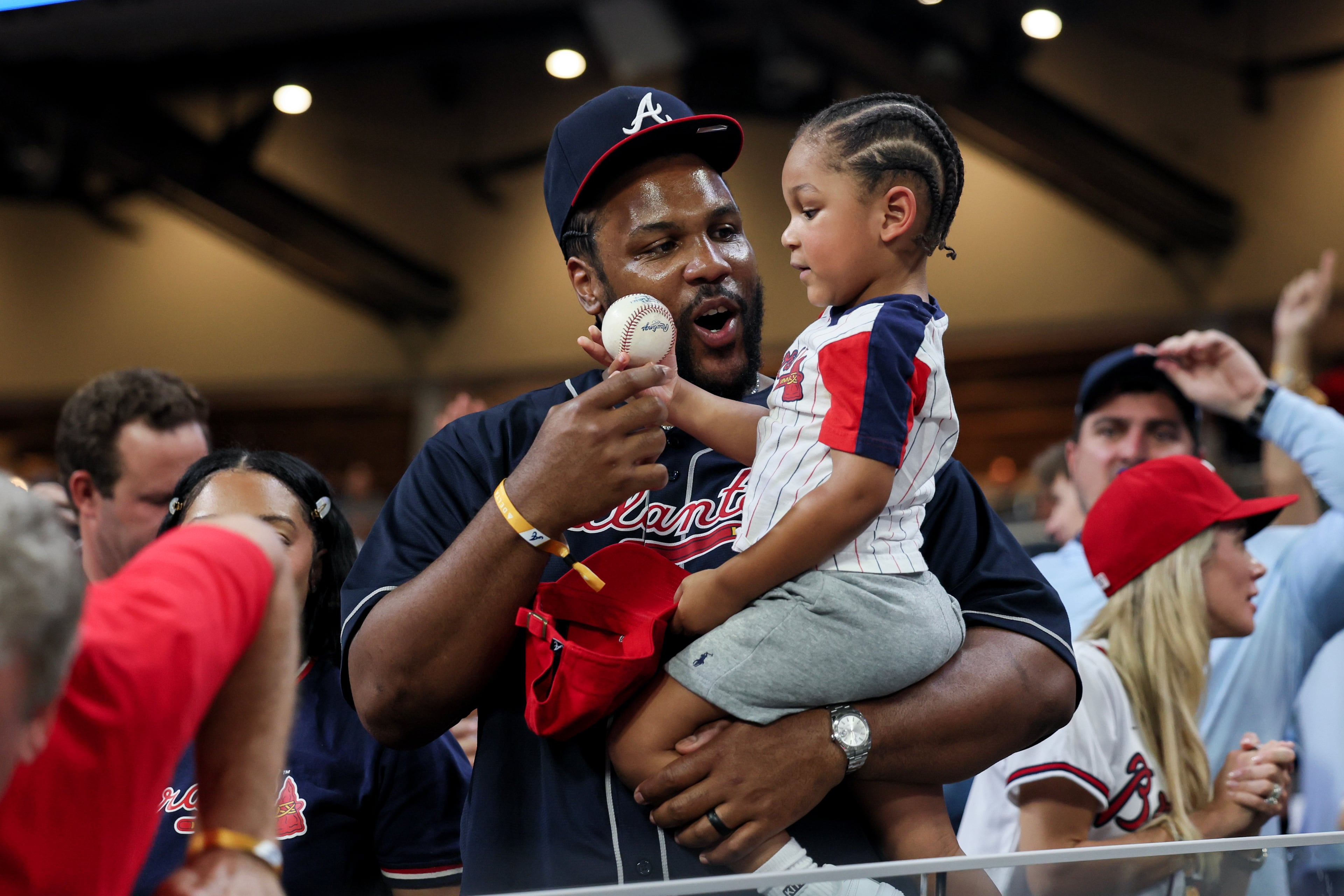 A child receives a baseball in the seventh inning during Game 3 of the NL Wild Card Series between the Braves and the Phillies on Thursday, Oct. 1, 2026, in Atlanta. (Jason Getz/AJC)