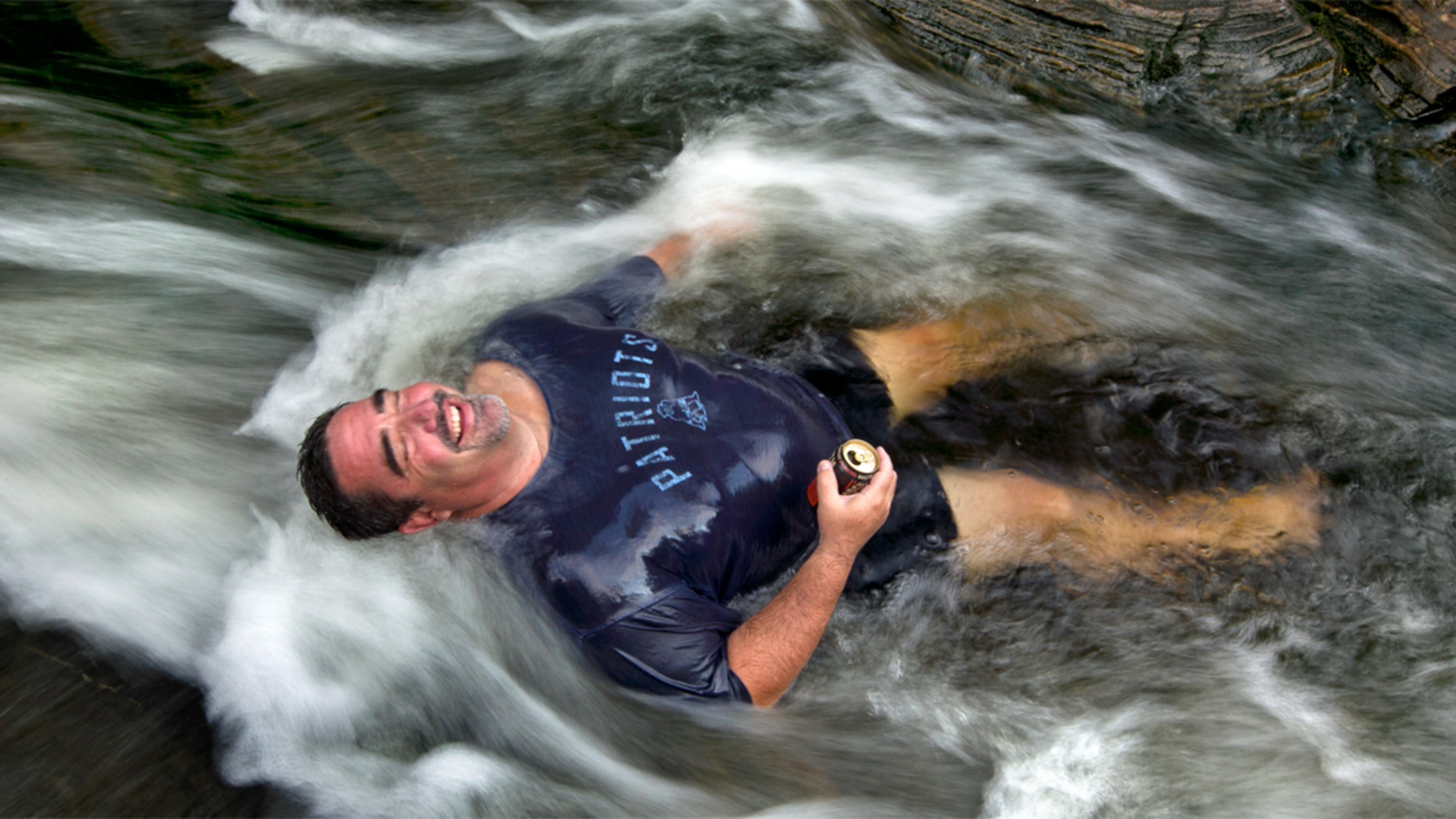 Troy Munford soaks in the waters of Sunday River in Riley Township, Maine, Wednesday, Aug. 19, 2015. Munford, a tour and travel sales manager at the Sunday River Ski Resort, and was with coworkers, enjoying an afternoon escape from work to beat the heat. "The whole office played hooky," he said. (AP Photo/Robert F. Bukaty)