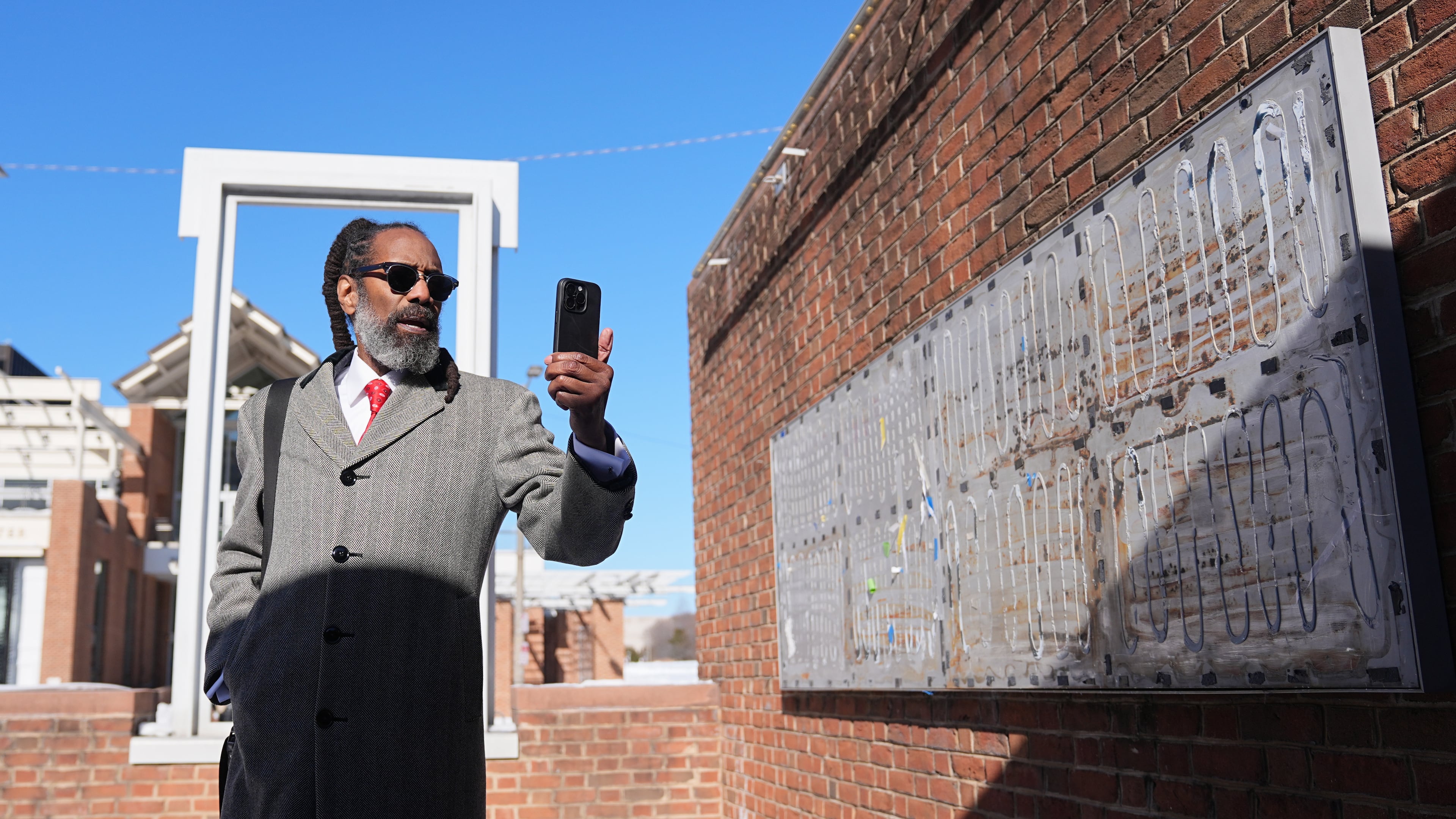 Attorney Michael Coard makes a social media post at the now removed explanatory panels that were part of an exhibit on slavery at President's House Site in Philadelphia, Friday, Jan. 30, 2026. (AP Photo/Matt Rourke)