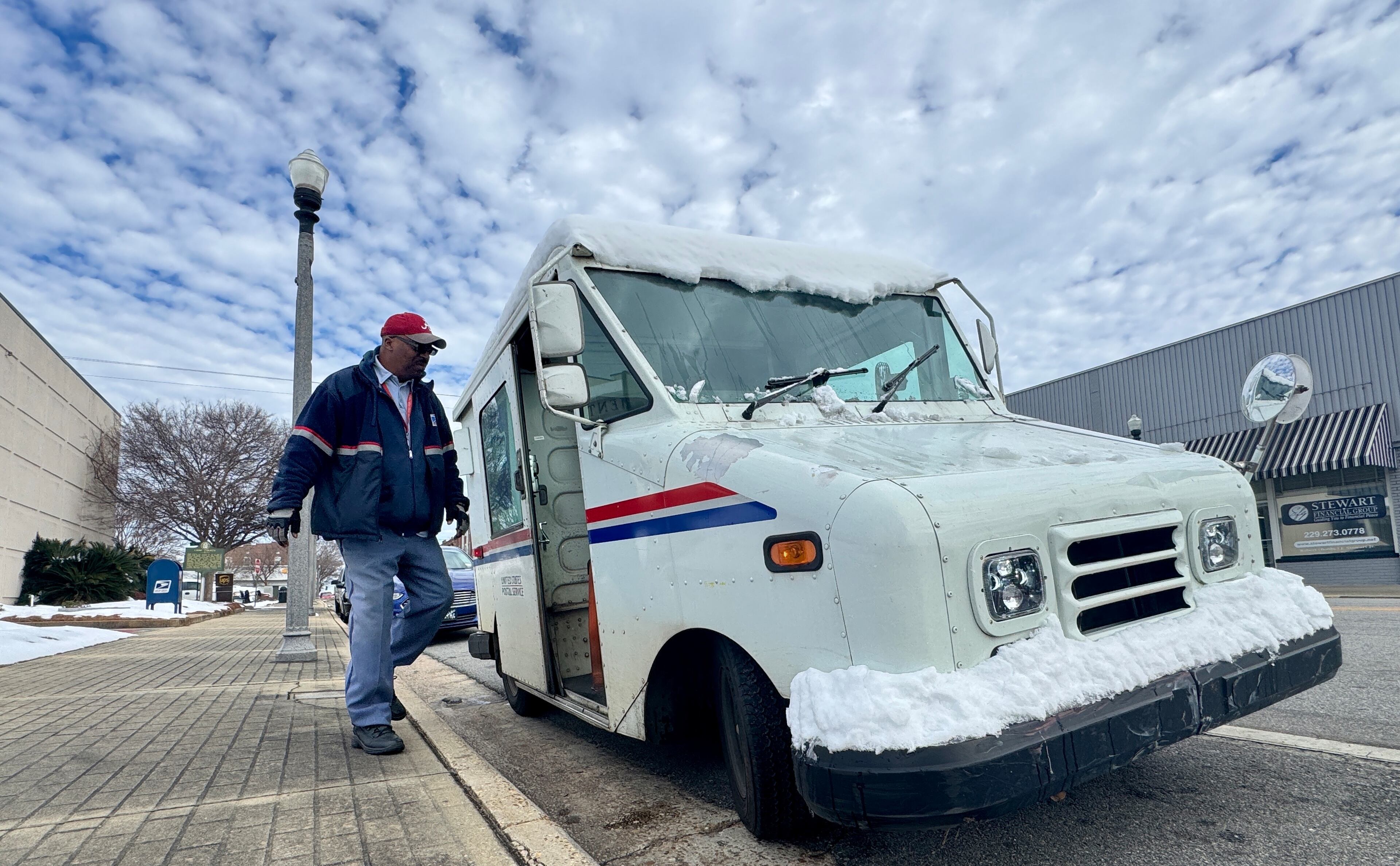 Mail carrier Al Mitchell climbs into his snow-coated truck parked outside City Hall in downtown Cordele on Thursday, Jan. 23, 2025. (Joe Kovac Jr./AJC)