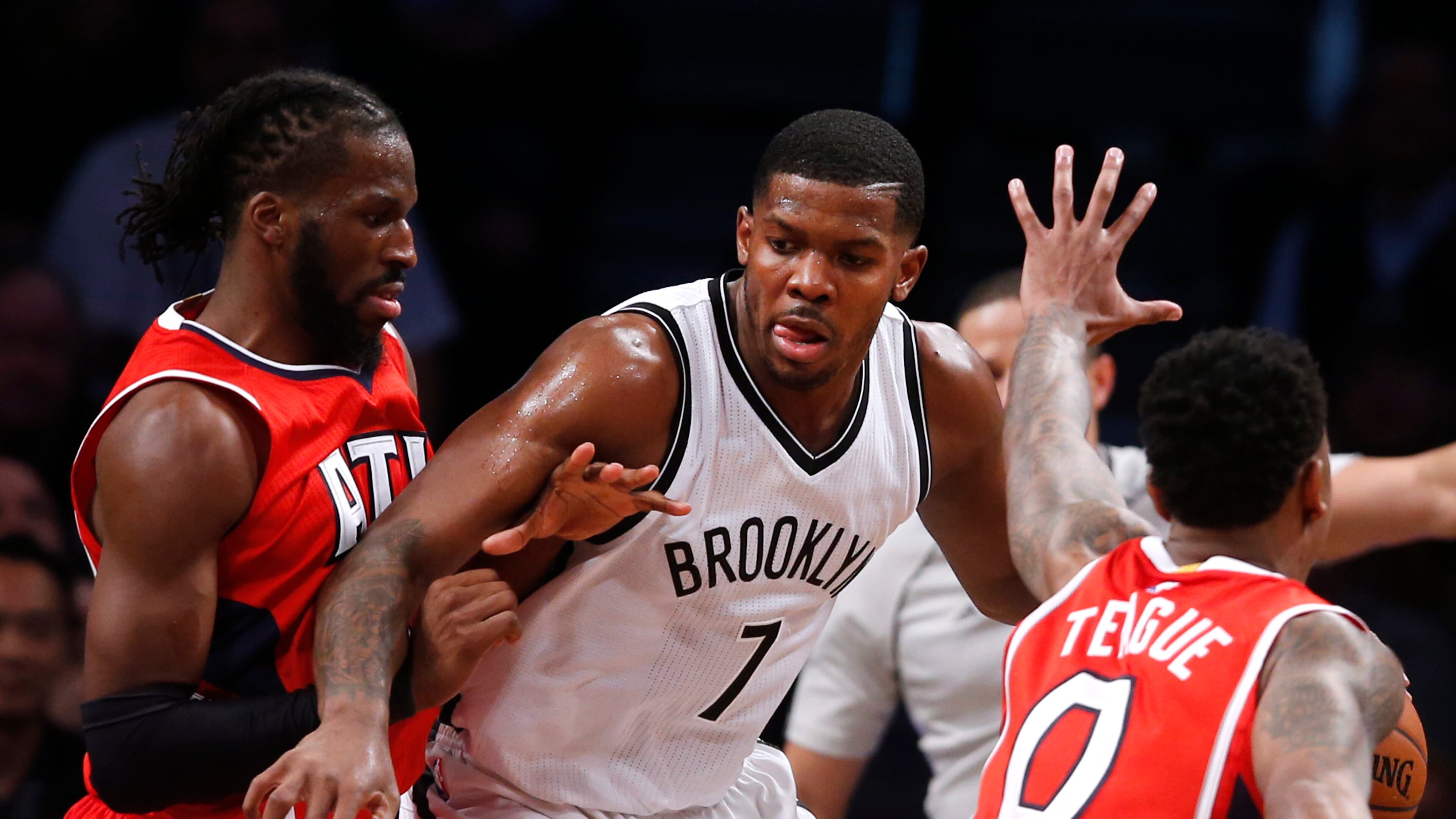 Brooklyn Nets' Joe Johnson (7) works against a double team from Atlanta Hawks' DeMarre Carroll, left, and Jeff Teague (0) during the fourth quarter of an NBA basketball game Wednesday, April 8, 2015, in New York. Atlanta defeated Brooklyn 114-111. (AP Photo/Jason DeCrow)