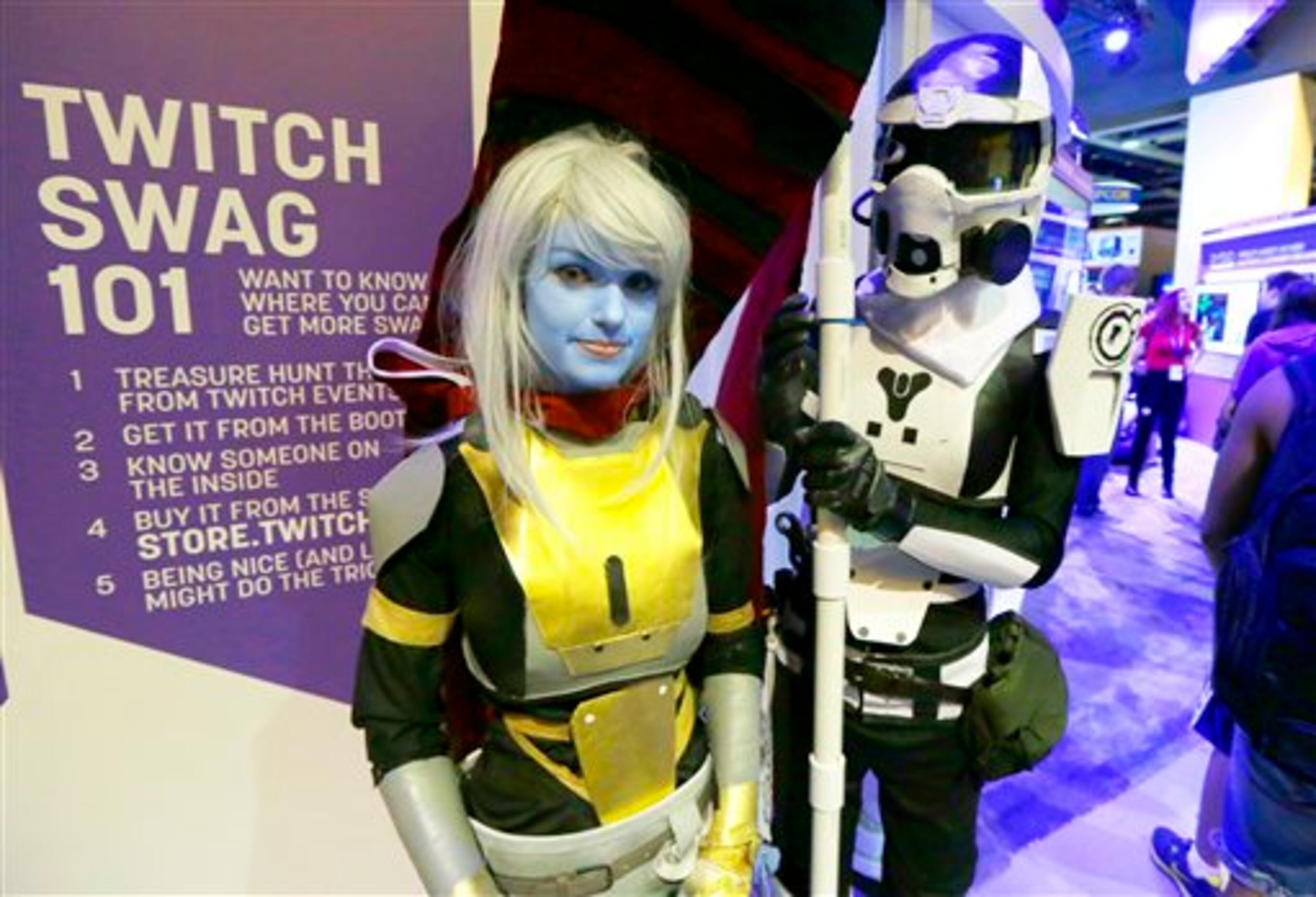 Teresa Price, left, and Steel Springer, right, dressed as hunter characters from the video game Destiny, wait in line to meet hosts of online gaming programs on the Twitch video game community, Friday, Aug. 29, 2014, at the Penny Arcade Expo, a fan-centric celebration of gaming in Seattle. The event is expected to be attended by roughly 85,000 gamers and will include concerts, game tournaments and previews of upcoming titles. (AP Photo/Ted S. Warren)