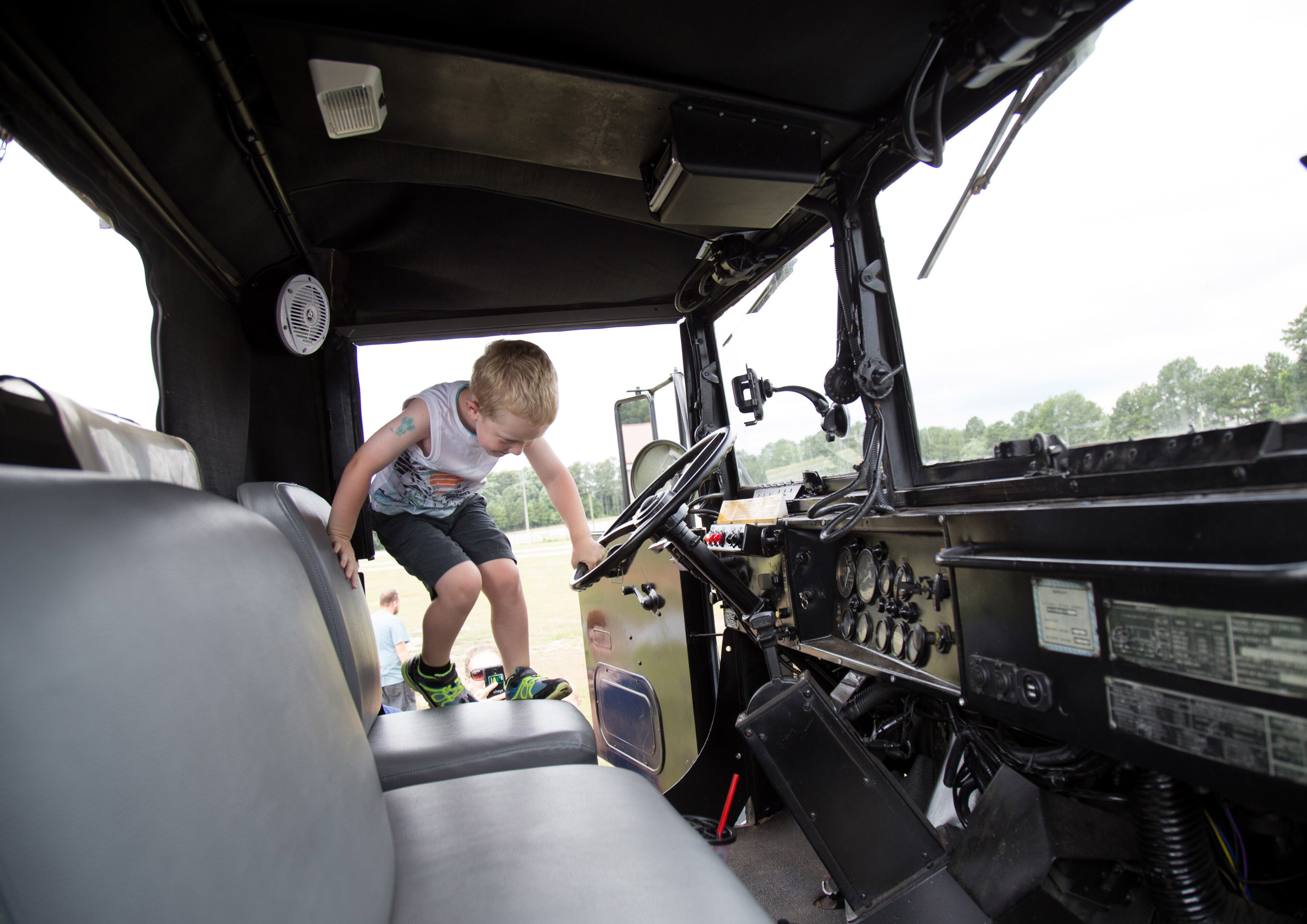 Ian Eich gets into a military troop transport vehicle during the Lift Up Summer Fun Festival on Saturday, June 18, 2016, in Lawrenceville, Ga. The proceeds from the festival will help homeless and low-income families. STEVE SCHAEFER / SPECIAL TO THE AJC