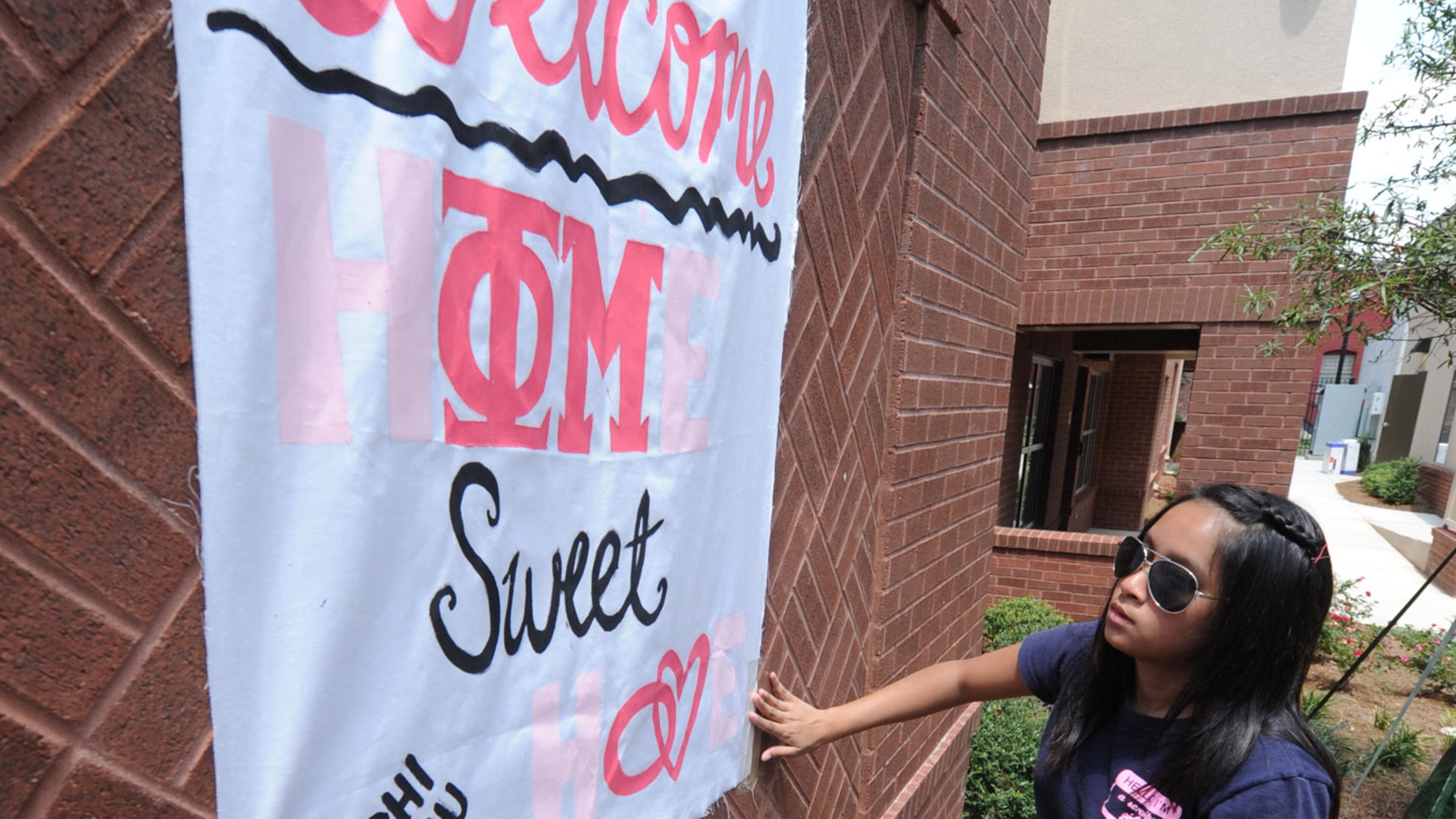 100812- Atlanta - Umama Kibria puts up a welcome sign for her Phi Mu sisters on Thursday AUG 12, 2010. Students moved into the new Special Interest Student House at Georgia State today. This is the Greek housing for the frats and sororities. It is nine three-story town homes with 139 beds at the corner of Edgewood and Piedmont. Nine of the 24 Greek organizations are moving in. The sororities that will live in Greek Housing this year are Alpha Omicron Pi, Alpha Xi Delta, Delta Zeta, Phi Mu and Zeta Tau Alpha. The fraternities are Kappa Sigma, Phi Beta Sigma, Pi Kappa Phi and Sigma Nu. JohnnyCrawford,Jcrawford@ajc.com
