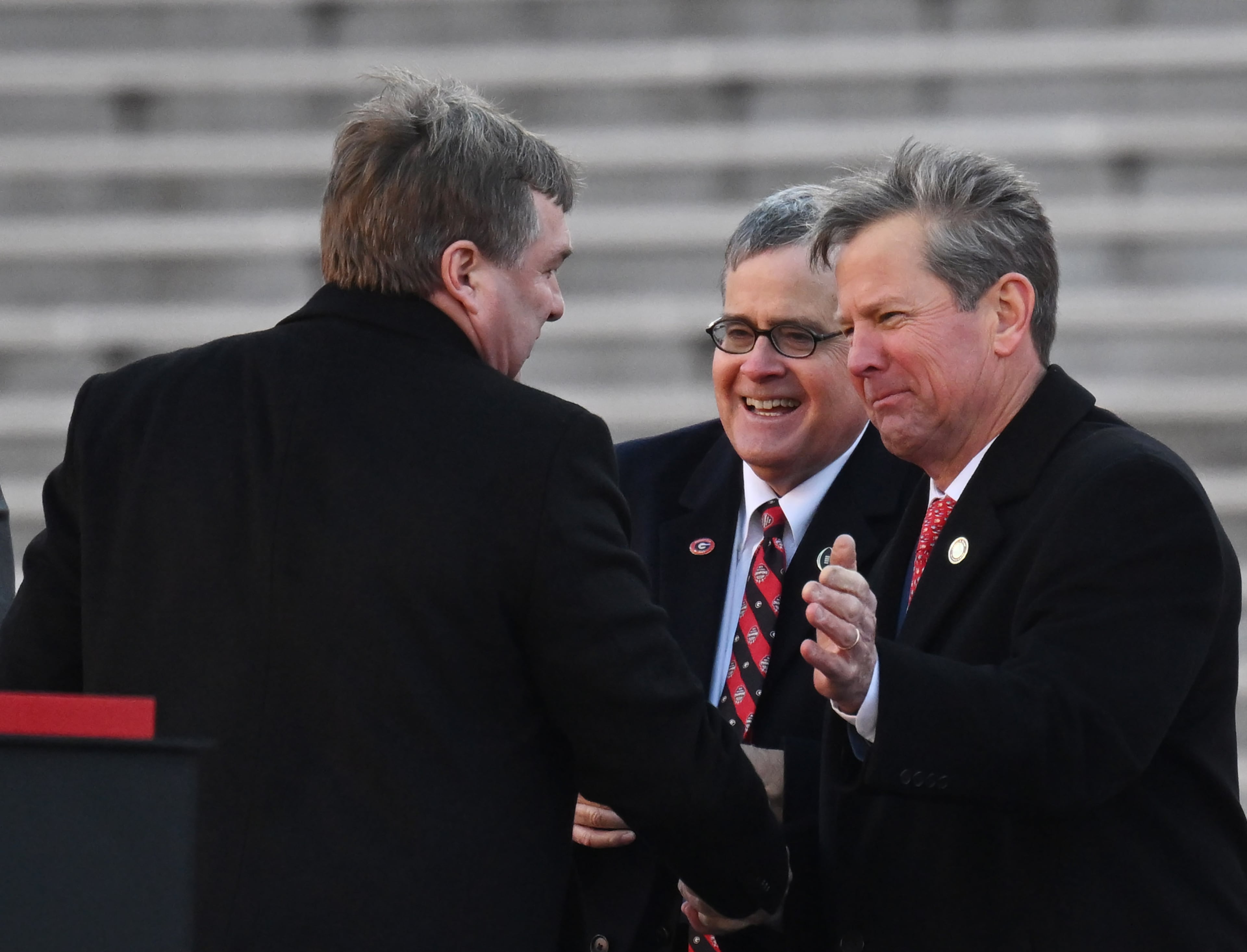 Georgia's head coach Kirby Smart (left) is greeted by UGA President Jere Morehead (center) and Governor Brian Kemp during the celebration of the Bulldogs going back-to-back to win the 2022 National Championship at Sanford Stadium, Saturday, Jan. 14, 2023, in Athens. (Hyosub Shin / Hyosub.Shin@ajc.com)