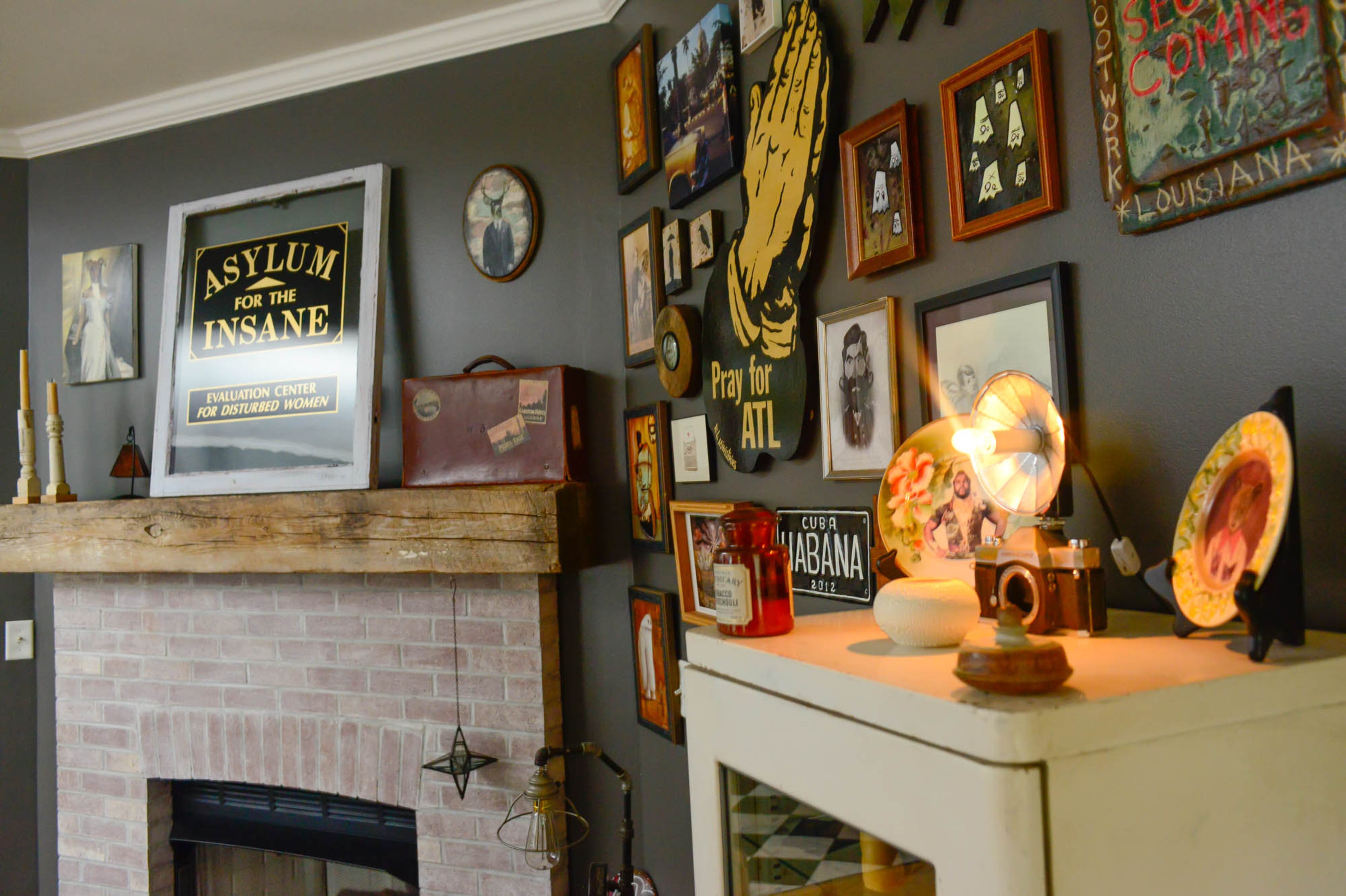 A window emblazoned with "Asylum for the Insane, " was a birthday gift from Gillese to Nash. Unusual art from around the world covers the walls of the couple's Cabbagetown home.