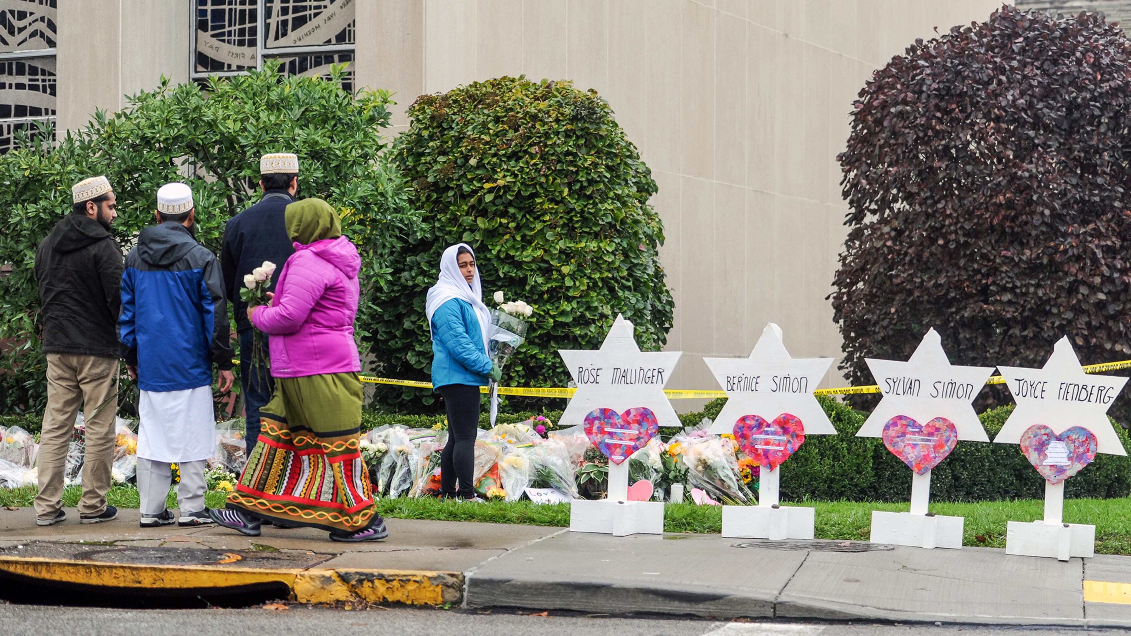 Members of Pittsburgh's Dawoodi Bohra Muslim community place flowers at the memorial in front of the Tree of Life synagogue, Sunday, Oct. 28, 2018, in the Squirrel Hill neighborhood of Pittsburgh. (Pittsburgh Post-Gazette/TNS)