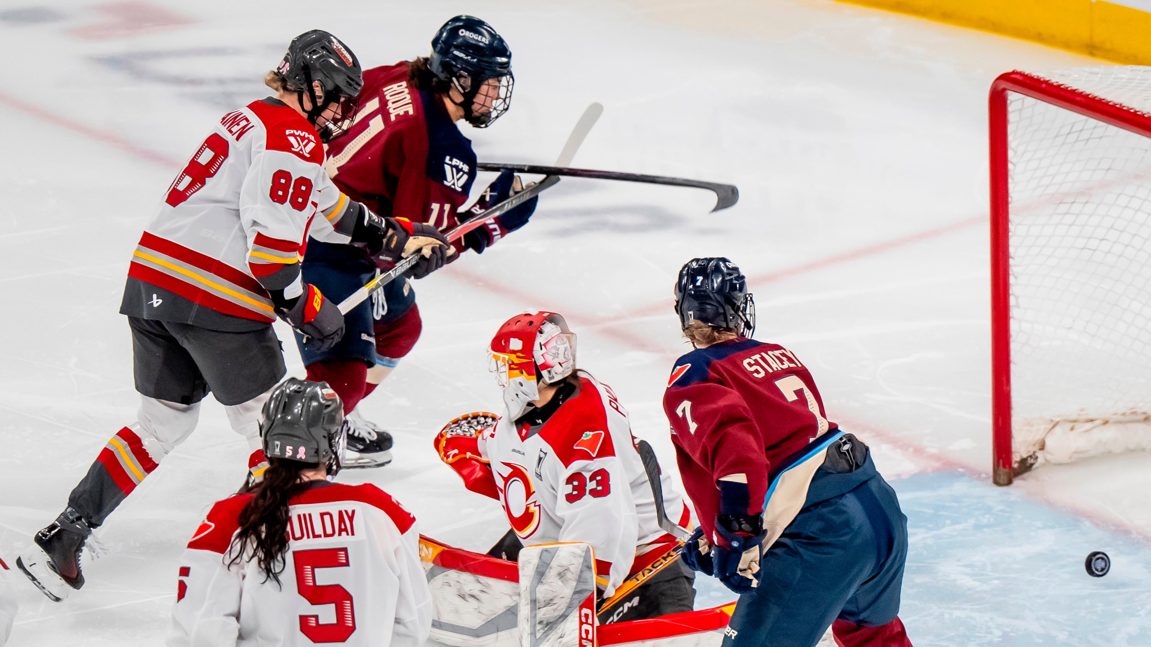 Montreal Victoire's Abby Roque (11) scores on Ottawa Charge goaltender Gwyneth Philips (33) during overtime of a PWHL playoff hockey game in Laval, Quebec, Thursday, May 14, 2026. (Christopher Katsarov/The Canadian Press via AP)