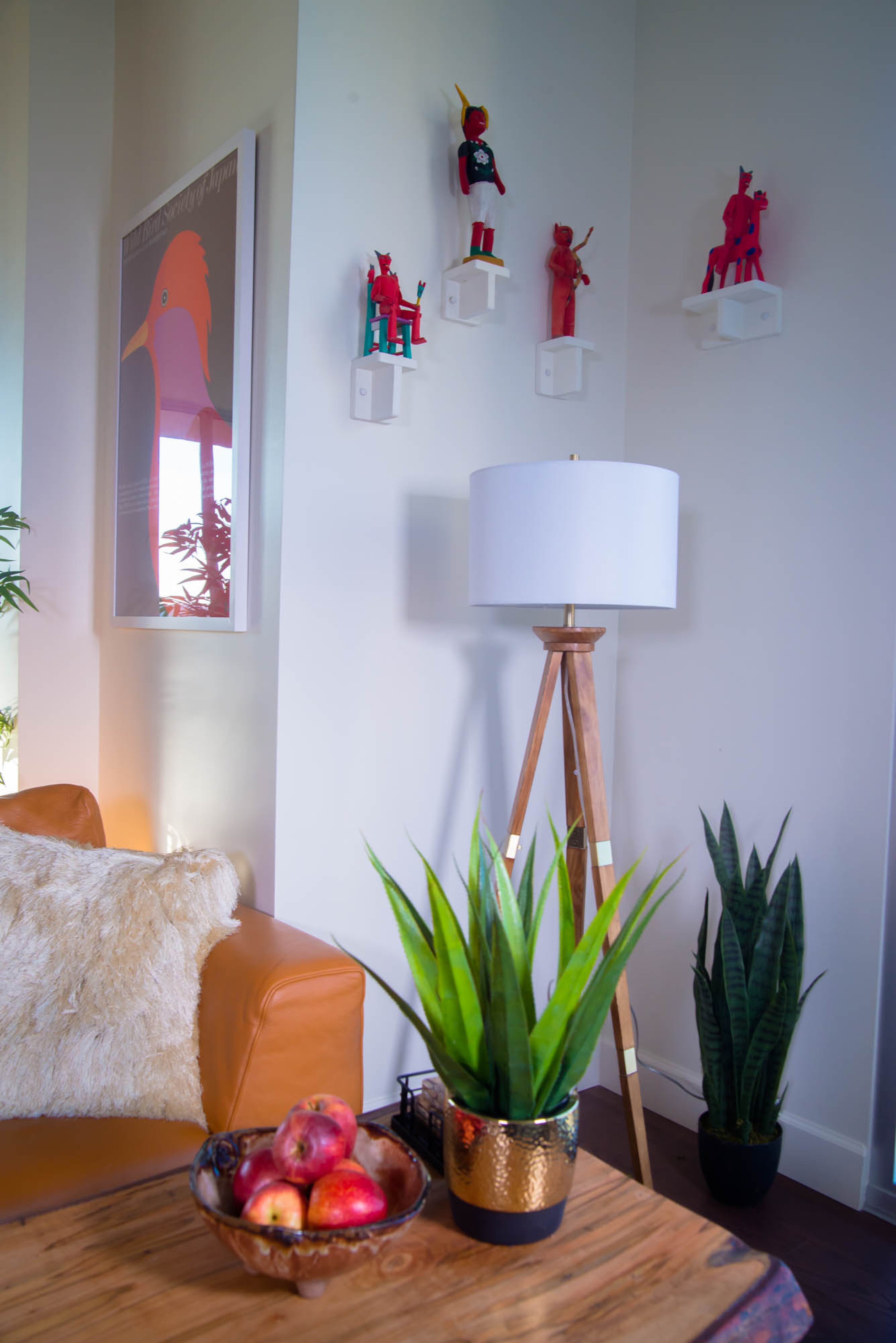 There is a confluence of mid-century modern furniture and folk art in the corner of Ron and Pippa Seichrist's Atlanta living room. Their wooden tripod lamp, a staple of the mid-century furniture movement, pairs nicely with the colorful figurines collected by the art-loving couple. Text by Anna Logan/Fast