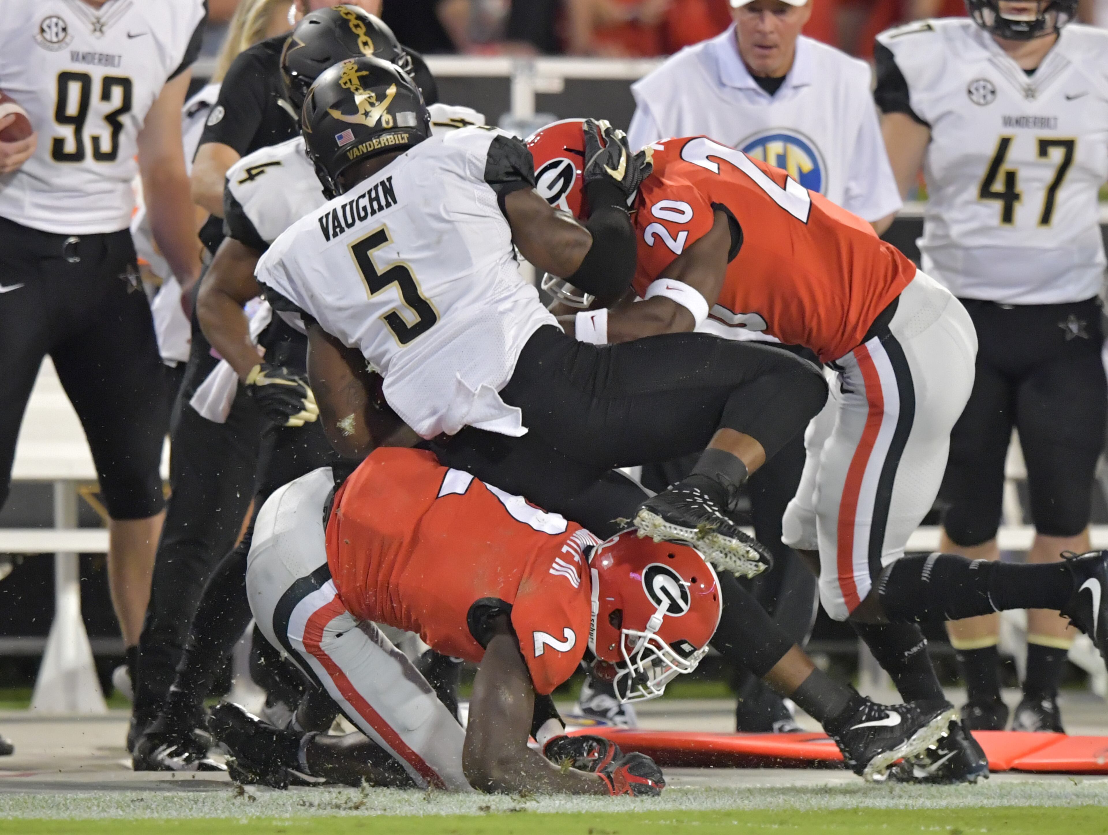 October 6, 2018 Athens - Vanderbilt running back Ke'Shawn Vaughn (5) gets tackled by Georgia defensive back Richard LeCounte (2) and Georgia defensive back J.R. Reed (20) in the first half during a NCAA college football game at Sanford Stadium in Athens on Saturday, October 6, 2018. HYOSUB SHIN / HSHIN@AJC.COM