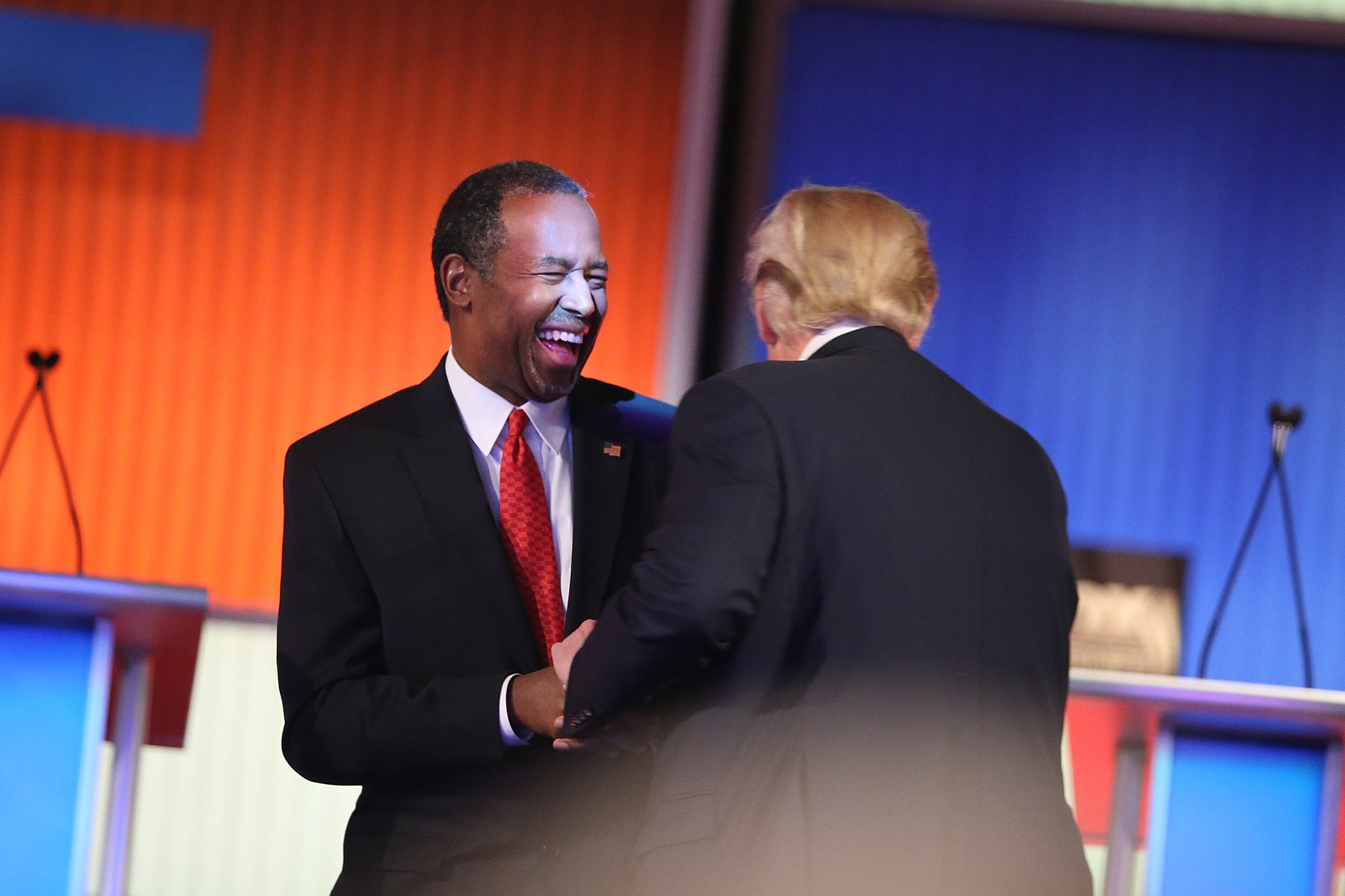 Republican presidential candidates Ben Carson and Donald Trump laugh during a commercial break during the Fox Business Network Republican presidential debate at the North Charleston Coliseum and Performing Arts Center on January 14, 2016 in North Charleston, South Carolina. (Photo by Scott Olson/Getty Images)