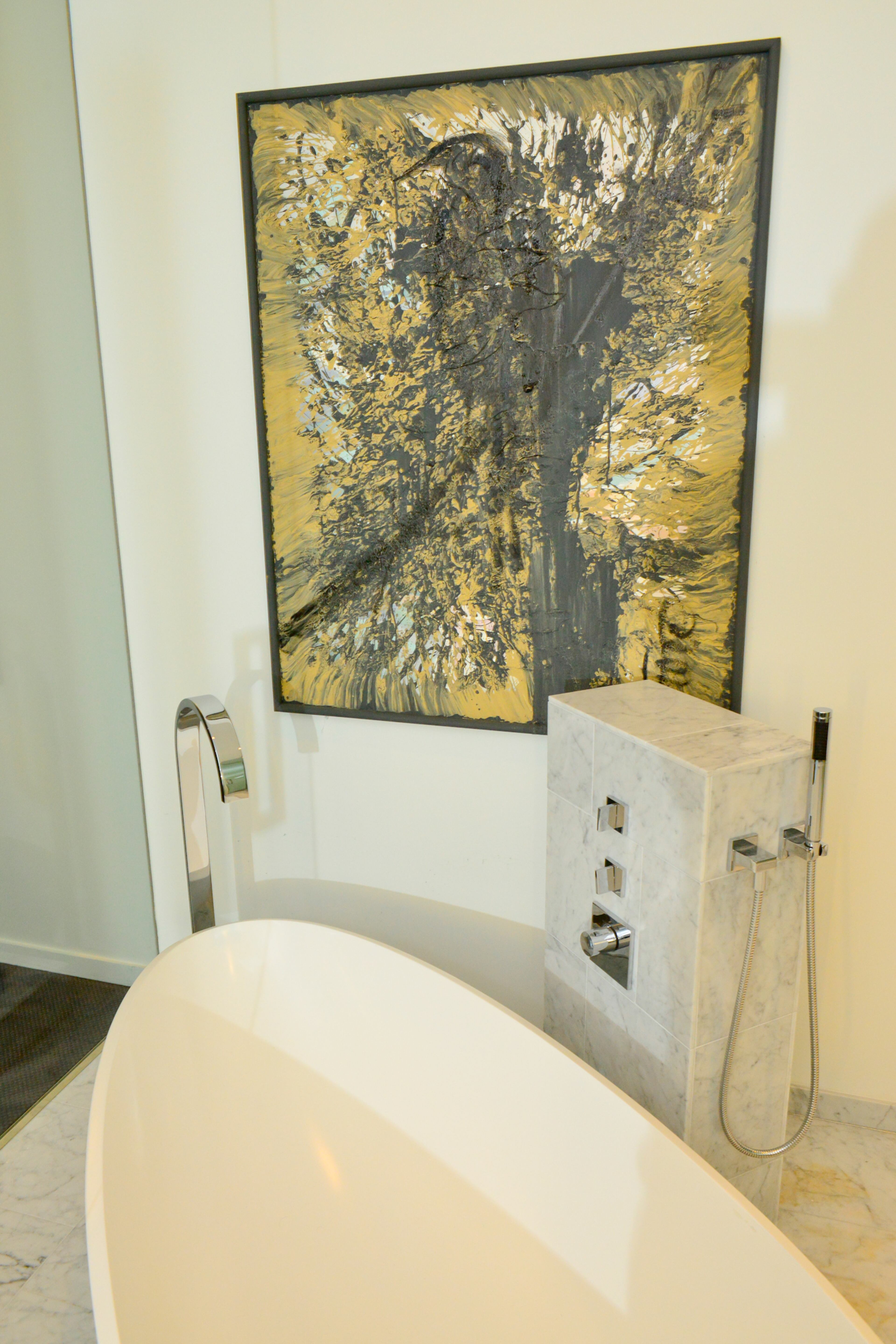 A freestanding bathtub was already selected for the space by the developers of the The Residences at W Atlanta - Downtown, along with marble floors. But the vast wall space enabled Marc Castillo to bring artwork (the artist is unknown) into the master bathroom.(Christopher Oquendo Photography)