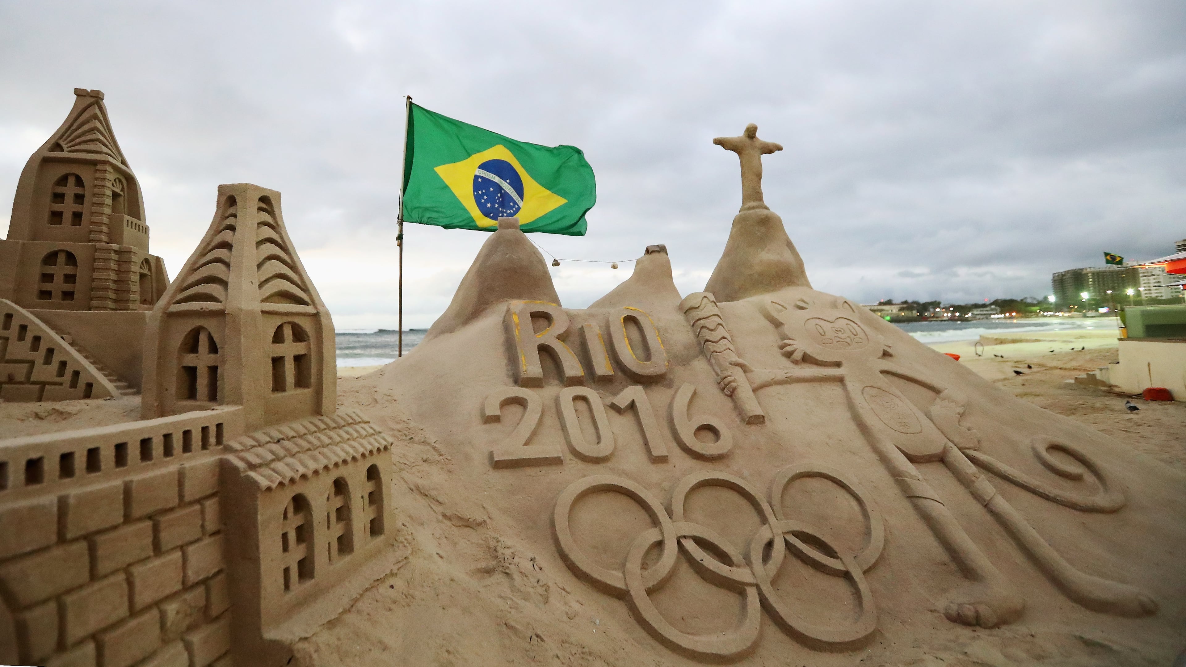 RIO DE JANEIRO, BRAZIL - AUGUST 01: A general view of the Olympic Rings, flag, Vinicius and Christ the Redeemer made into a sand sculpture on the beach during the Olympics preview day - 5 at the Copacabana Beach on July 30, 2016 in Rio de Janeiro, Brazil. (Photo by Dean Mouhtaropoulos/Getty Images)