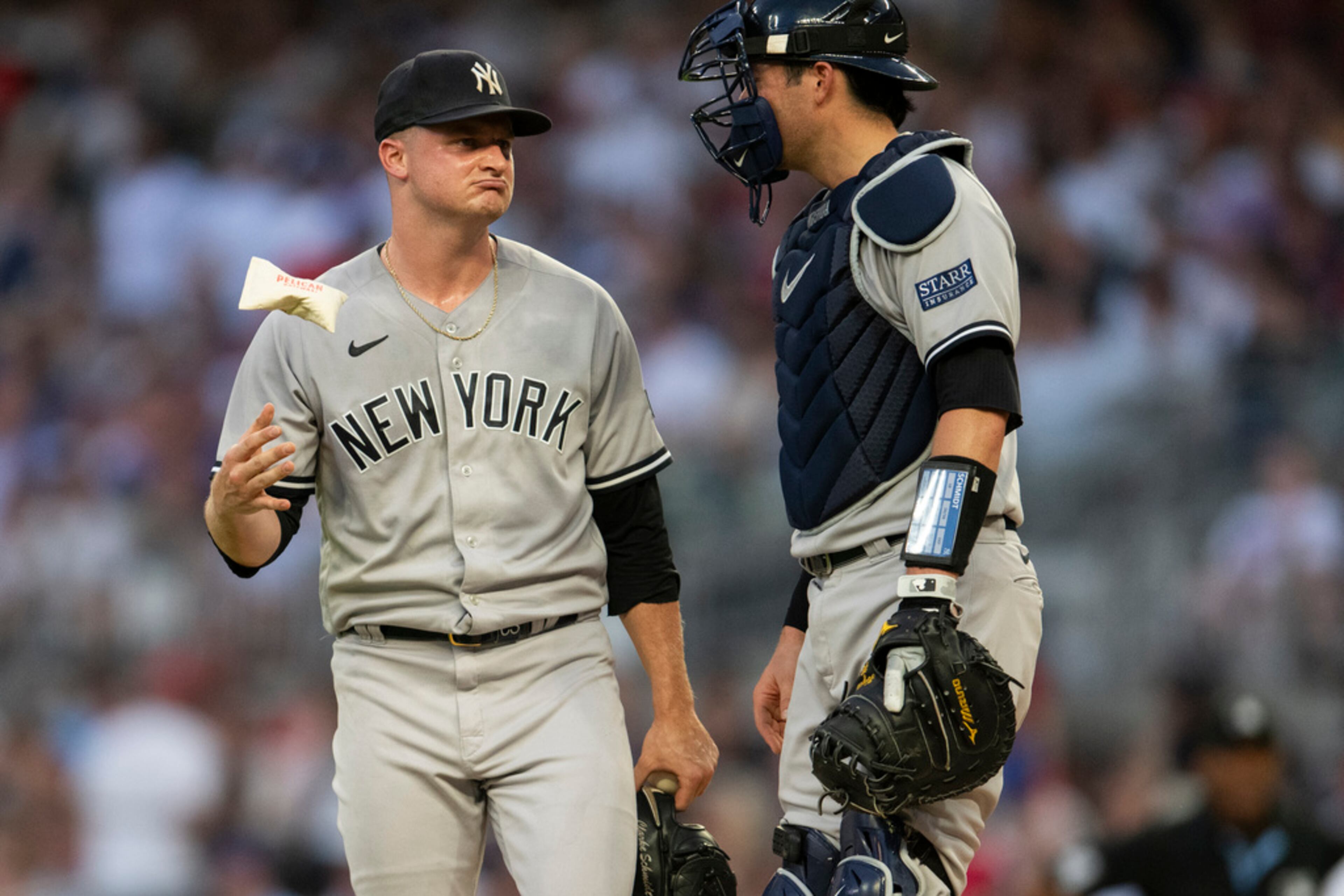 New York Yankees' catcher Kyle Higashioka, right, visits the mound to speak with starting pitcher Clarke Schmidt, left, in the second inning of a baseball game against the Atlanta Braves, Monday, Aug. 14, 2023, in Atlanta. (AP Photo/Hakim Wright Sr.)