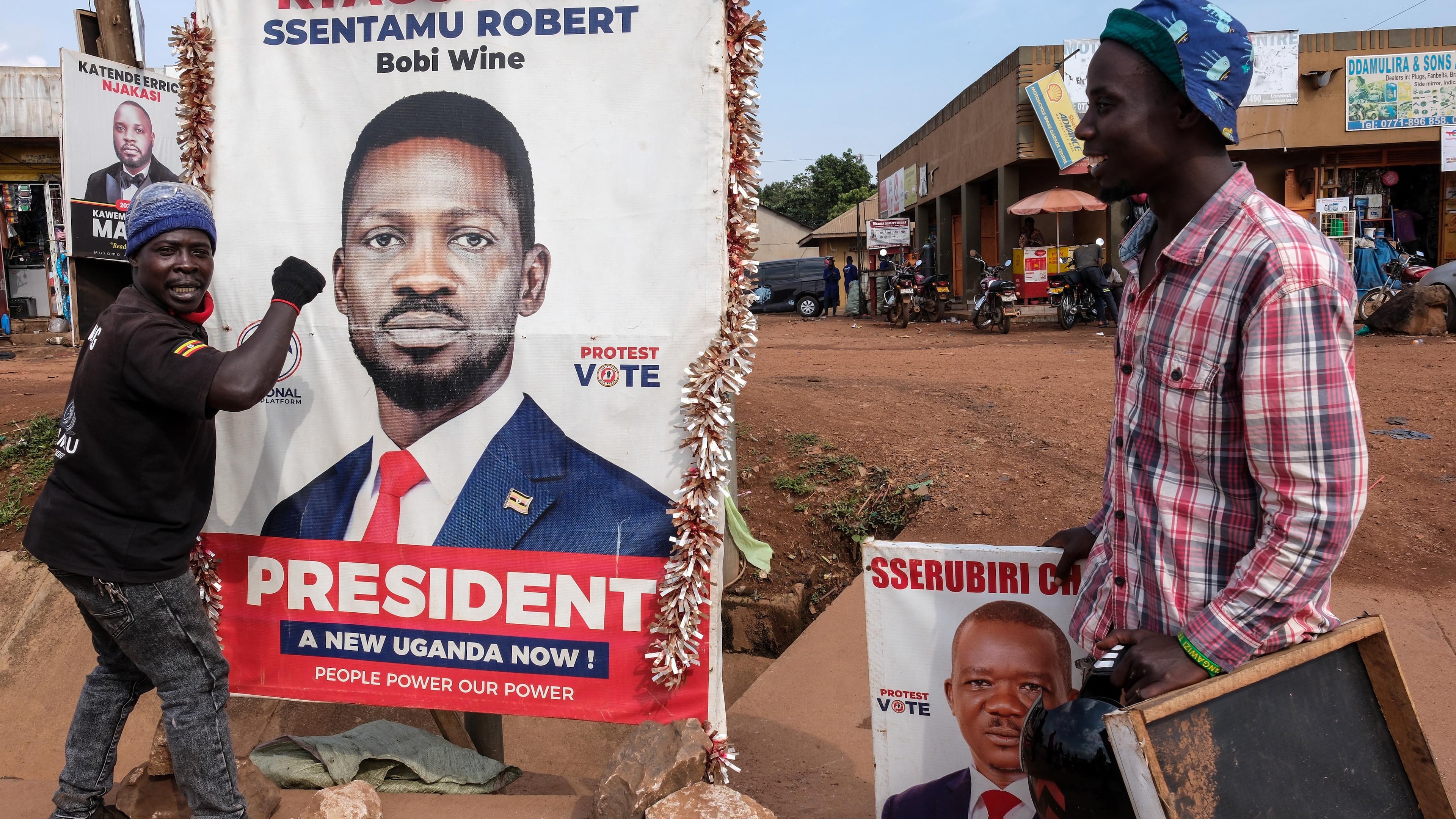 A supporter of Uganda opposition presidential candidate Robert Kyagulanyi Ssentamu, known as Bobi Wine, holds onto a campaign poster in Kampala, Uganda, Tuesday, Jan. 13, 2026. (AP Photo/Hajarah Nalwadda)
