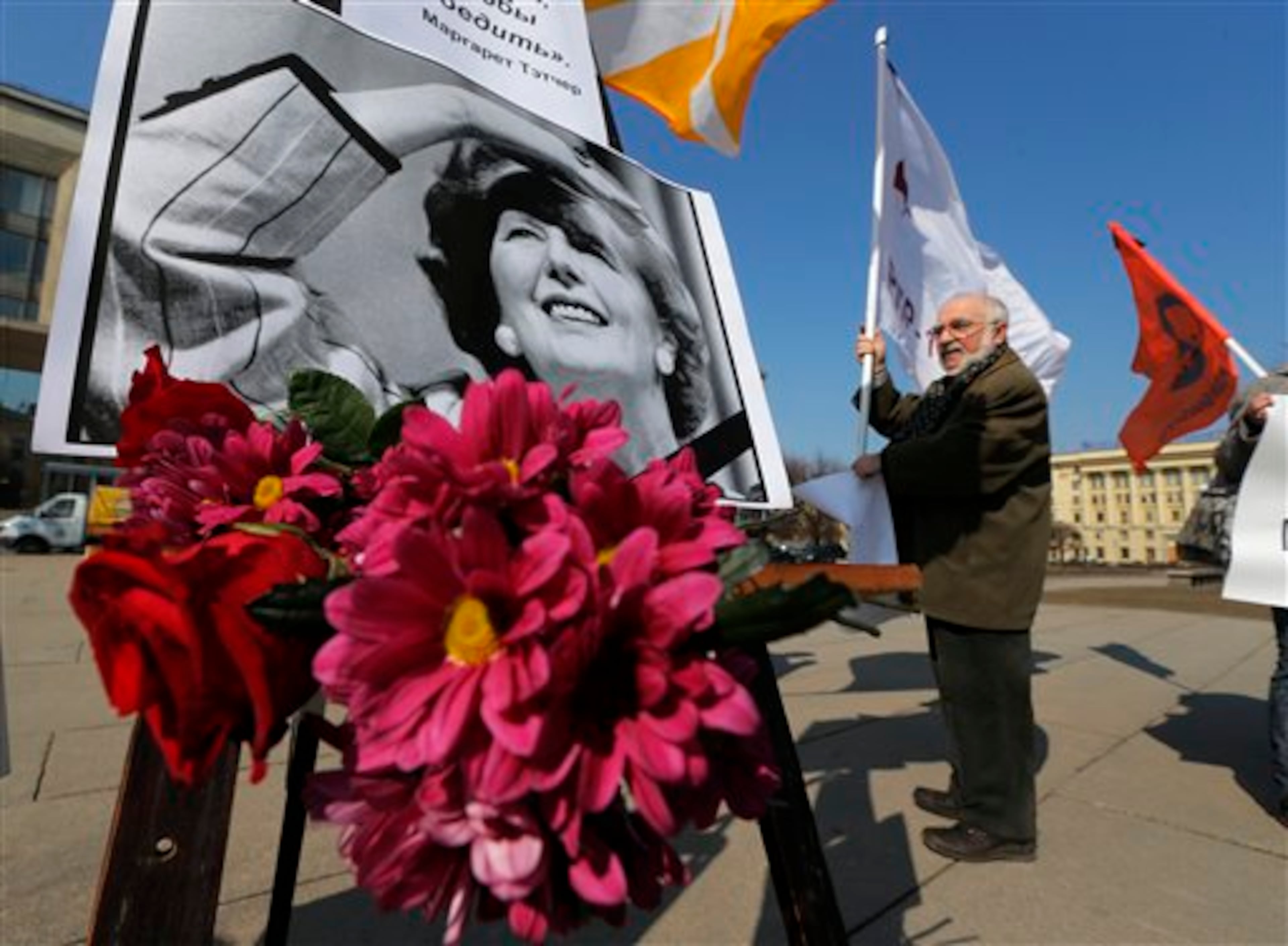 Members of democratic party Parnas place flowers under a portrait of former British Prime Minister Margaret Thatcher near to the British consulate in St.Petersburg, Russia, Wednesday, April 17, 2013, on the day of her funeral taking place in London. The poster quotes Thatcher in Russian, reading: I'm continuing my battle. I'm fighting to win. The coffin containing the body of former Prime Minister Margaret Thatcher was driven Wednesday, April 17, 2013, from the Houses of Parliament to the church of St. Clement Danes for prayers ahead of the former leader's full ceremonial funeral at St. Paul's Cathedral in London.(AP Photo/Dmitry Lovetsky)
