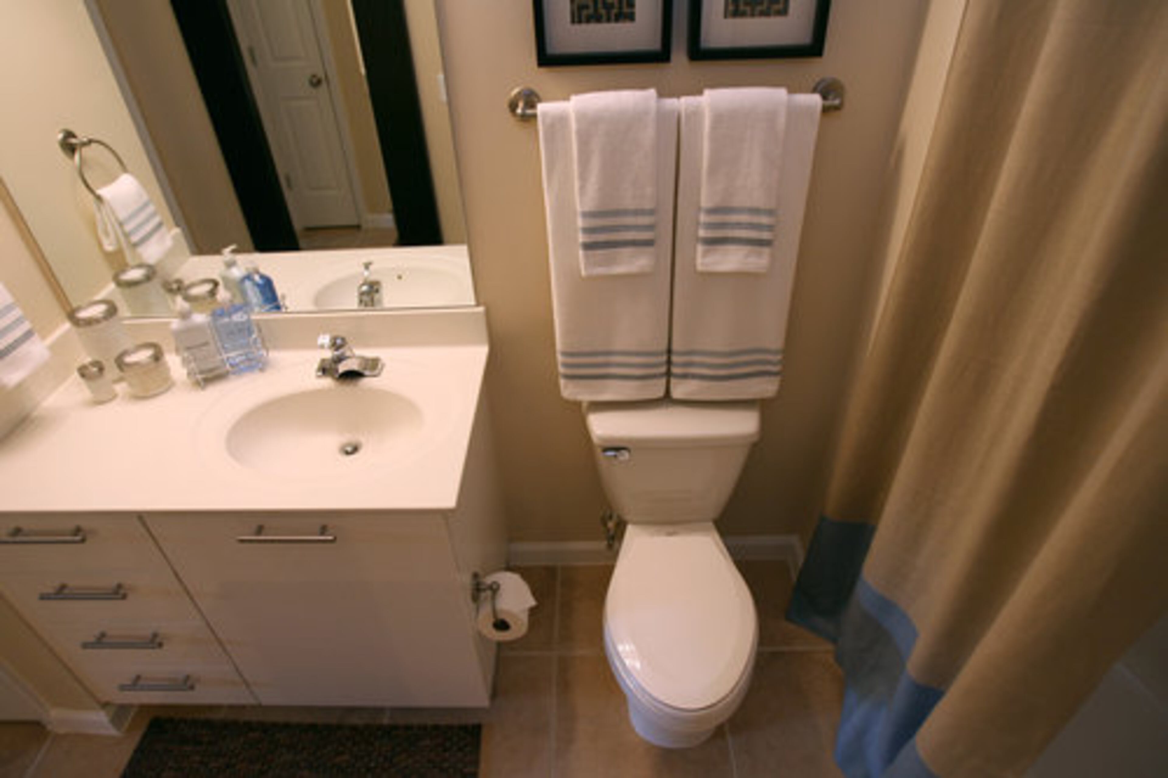 Bathroom accessories are creme, brown and blue to match the decor in the rest of the apartment.