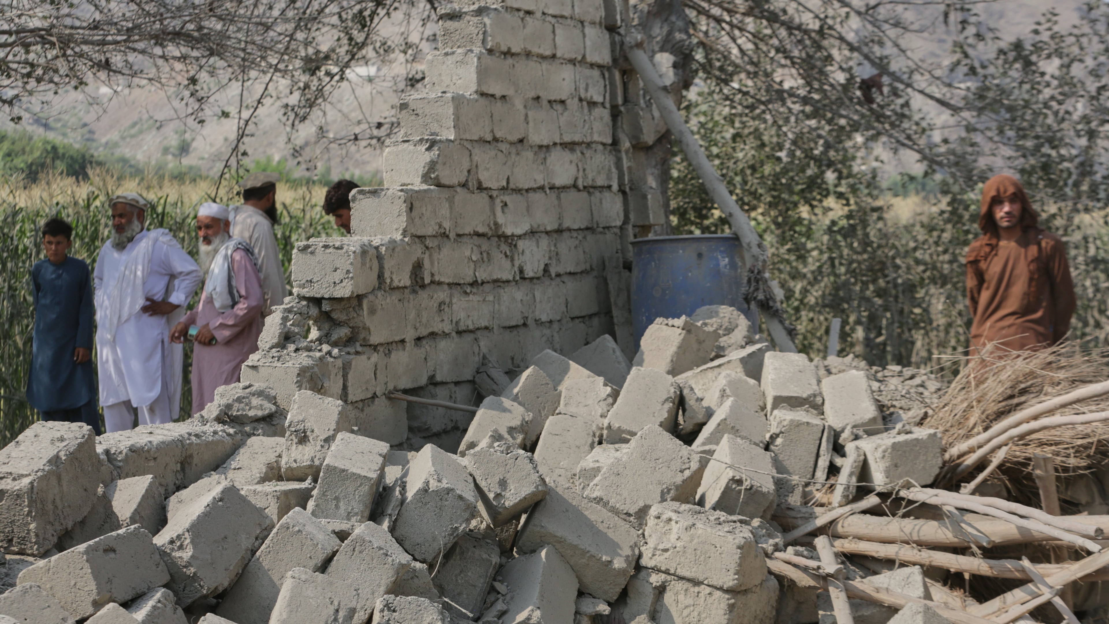 Residents stand near a collapsed wall of a house damaged in a strike in Patan village, Kunar province, eastern Afghanistan, Monday, Sept. 21, 2026. (AP Photo/Shafiullah Kakar)