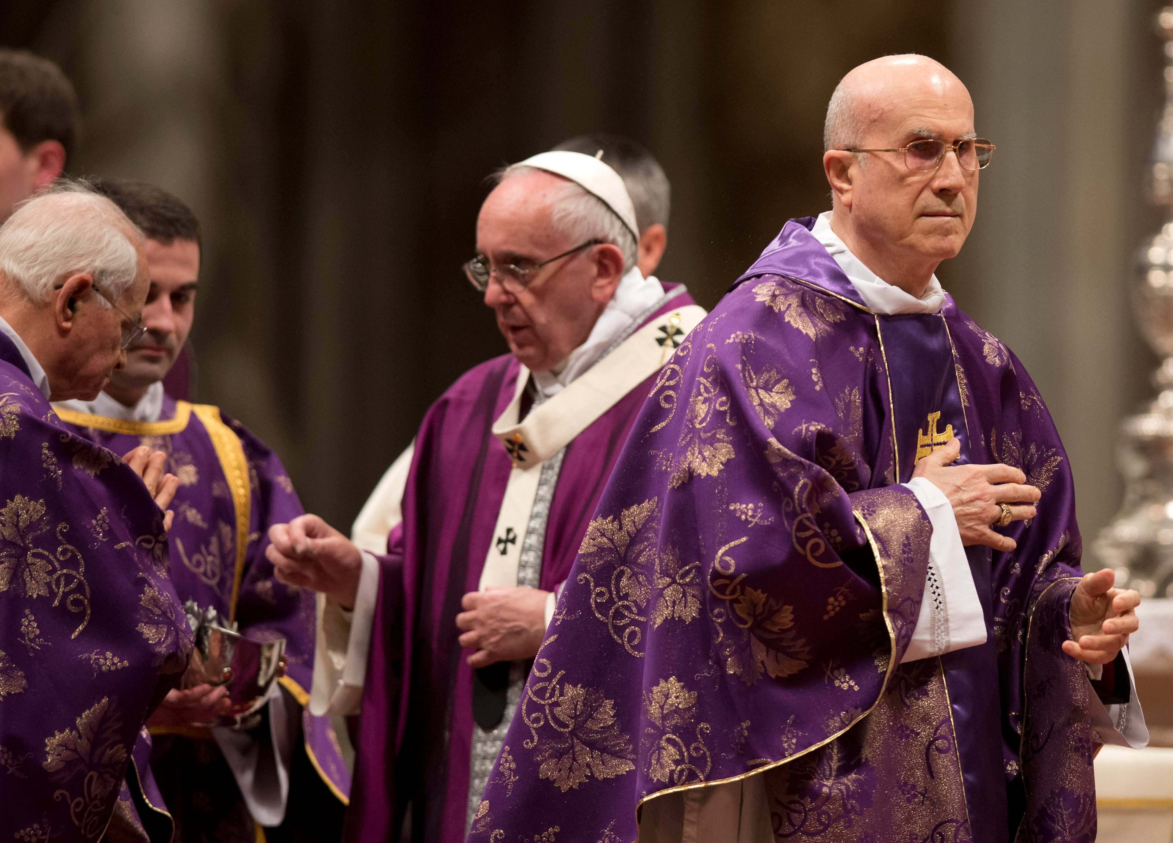 Cardinal Tarcisio Bertone, right, walks after receiving the ashes from Pope Francis, center, during the Ash Wednesday mass, in St. Peter's Basilica at the Vatican, Wednesday, Feb. 10, 2016. Pope Francis has smudged ashes on the bowed heads of prelates, nuns and ordinary Catholics during Ash Wednesday Mass in St. Peter�s Basilica. The ritual marks the start of Lent, a period of penitence, prayer and self-sacrifice as faithful prepare for Easter. (AP Photo/Alessandra Tarantino)