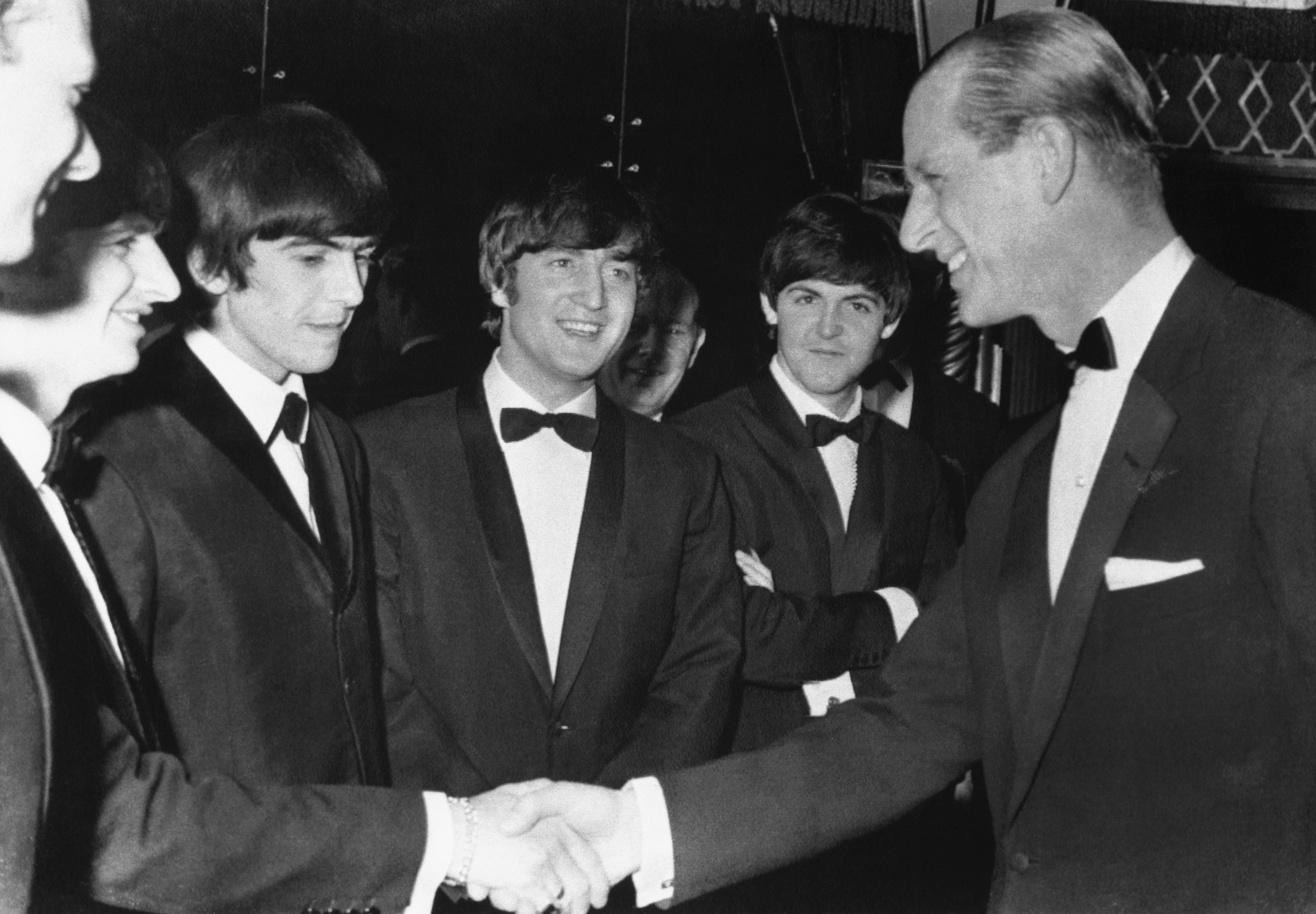 (Original Caption) The Prince is Confirmed Beatle Fan. London: Prince Philip (R) has just been confirmed a loyal Beatle fan as he shakes with the Beatle drummer Ringo Starr while other Beatles (L to R) George Harrison, John Lennon and Paul McCartney look on. The Prince met the rock and rolling, mop haired quartet when he was a the Empire ballroom in Leicester Square March 23 to present the Carl Alan awards. At extreme left is Beatle manager Brian Epstein.