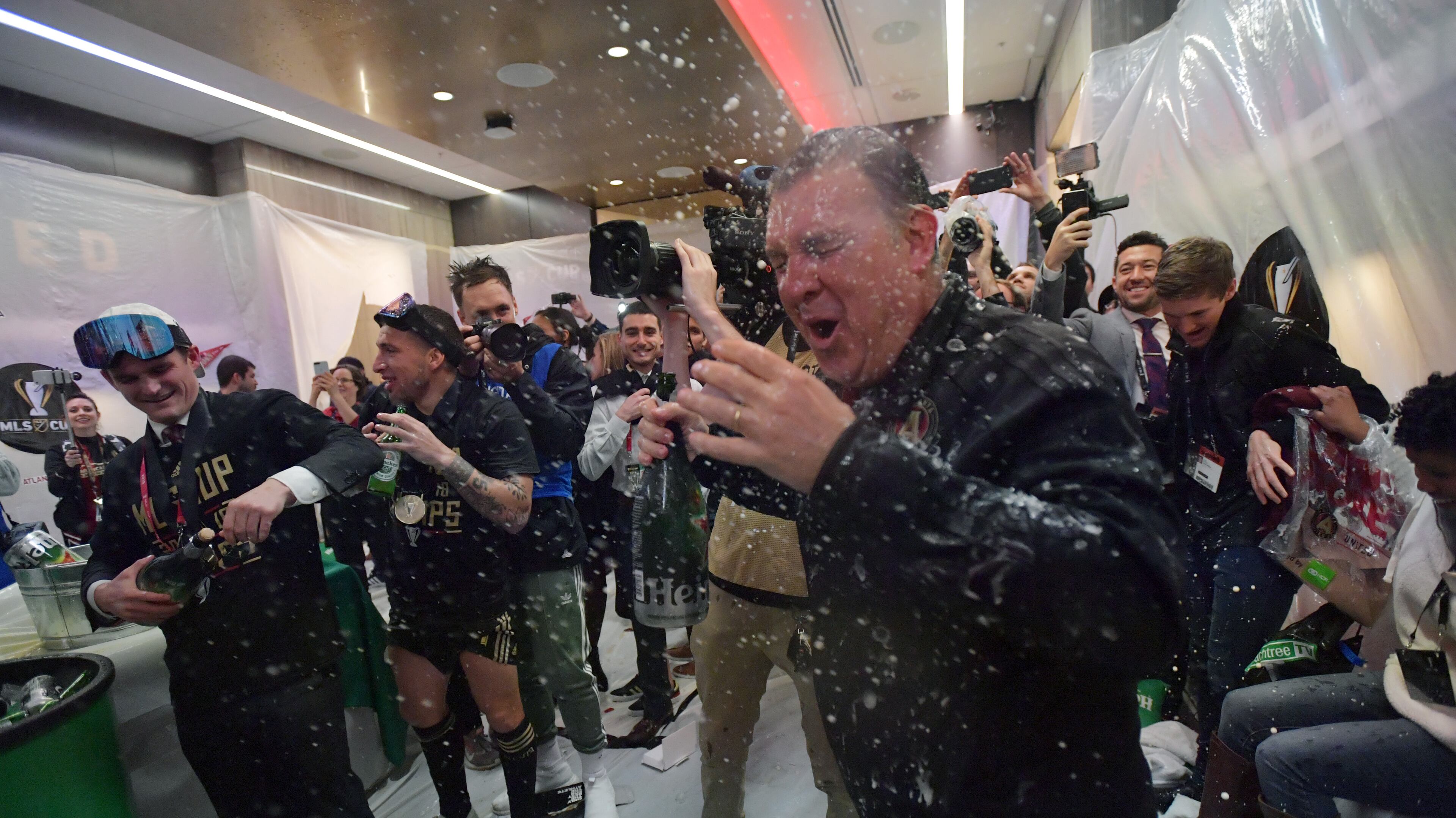 Atlanta United head coach Gerardo Martino gets soaked with bears as players celebrate in their locker room after Atlanta United beat the Portland Timbers during the MLS championship on Saturday, December 8, 2018. HYOSUB SHIN / HSHIN@AJC.COM