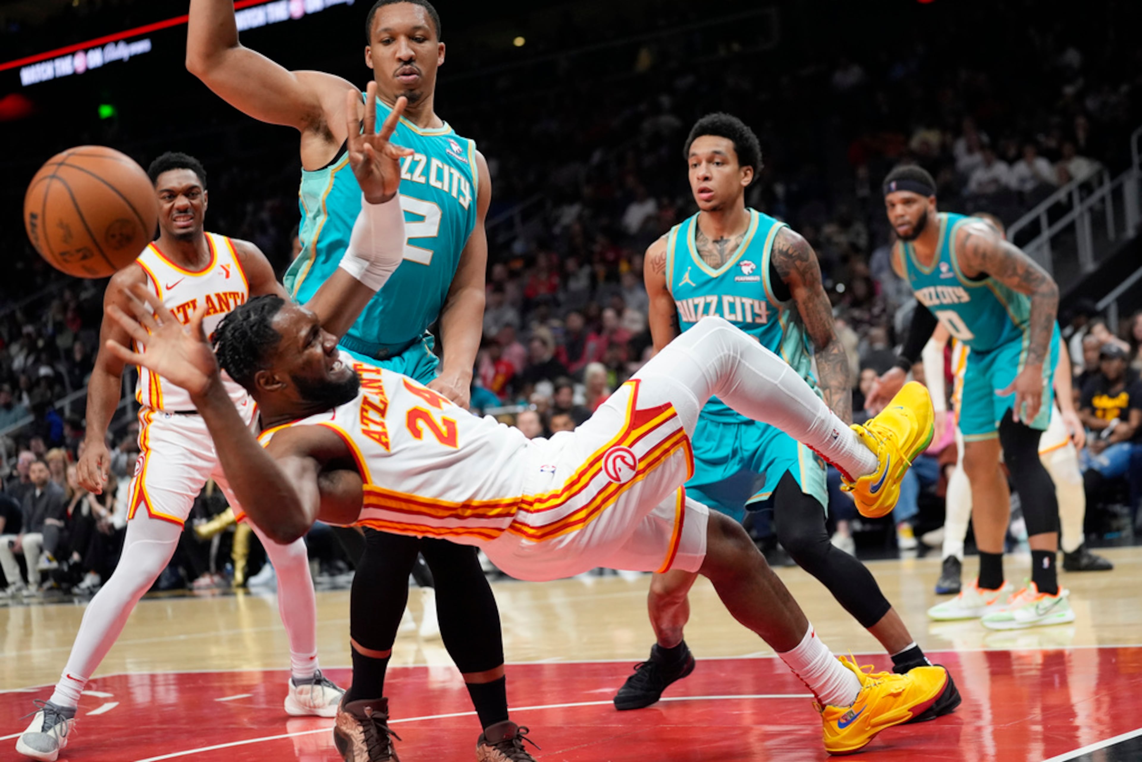 Atlanta Hawks forward Bruno Fernando (24) falls in front of Charlotte Hornets forward Grant Williams (2) after being fouled during the second half of an NBA basketball game Saturday, March 23, 2024, in Atlanta. (AP Photo/John Bazemore)