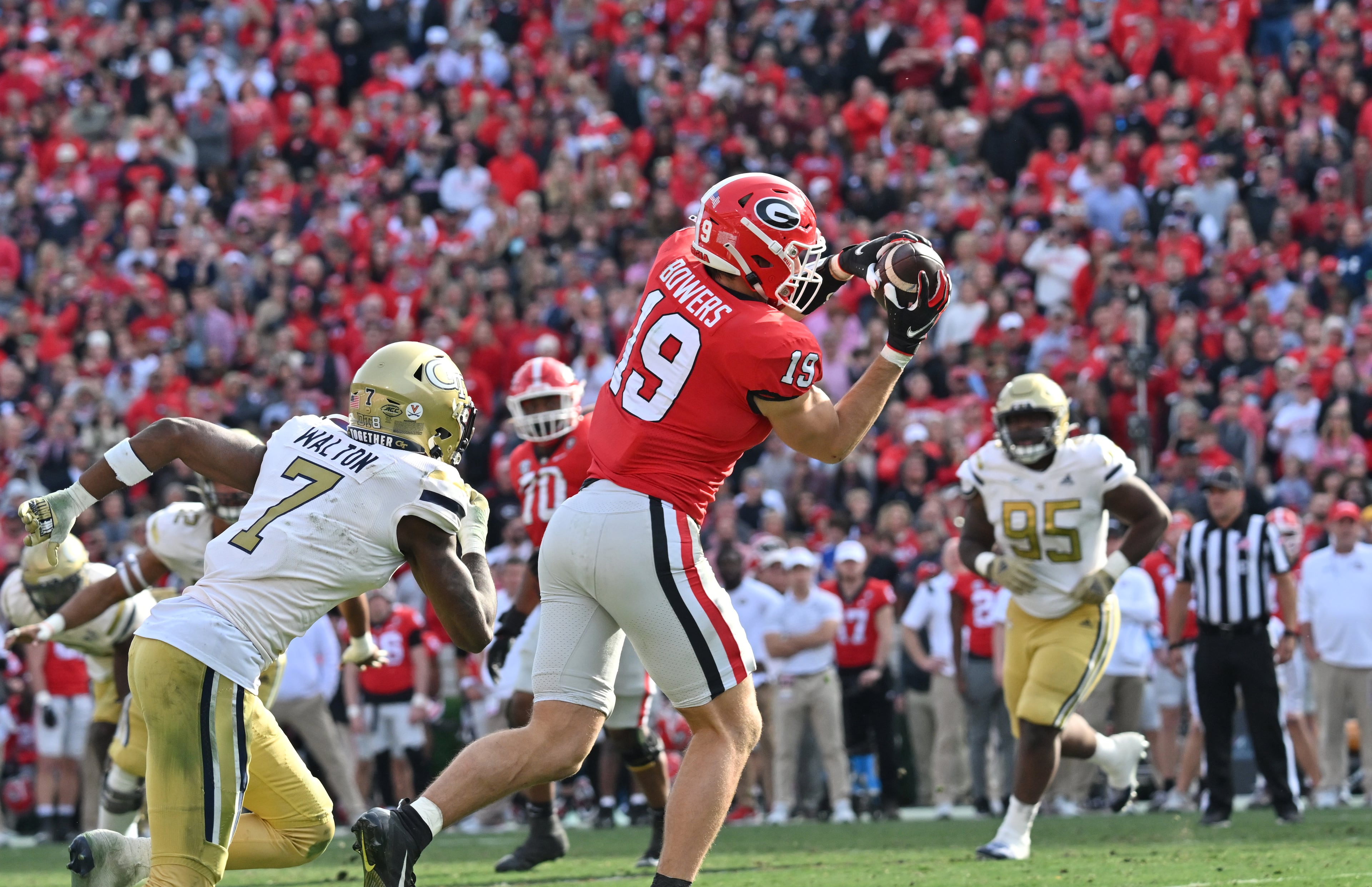 Georgia's tight end Brock Bowers (19) catches a pass over Georgia Tech's defensive back Zamari Walton (7) during the second half in an NCAA football game at Sanford Stadium in Athens on Saturday, November 26, 2022. Georgia won 37-14 over Georgia Tech. (Hyosub Shin / Hyosub.Shin@ajc.com)