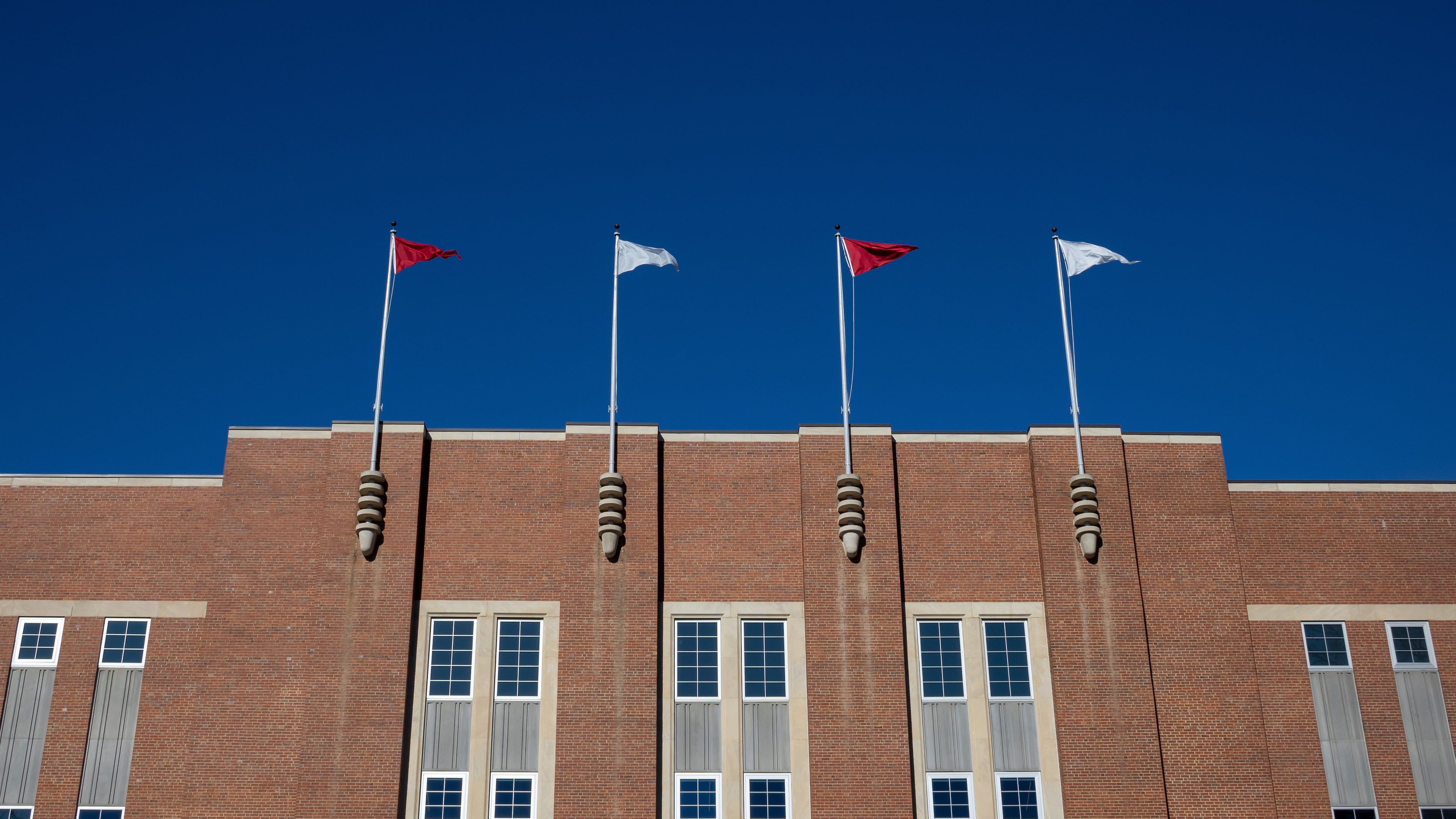 FILE - Flags fly at the Reynolds Coliseum at North Carolina State University Feb. 19, 2022, in Raleigh, N.C. (AP Photo/Kara Durrette, File)