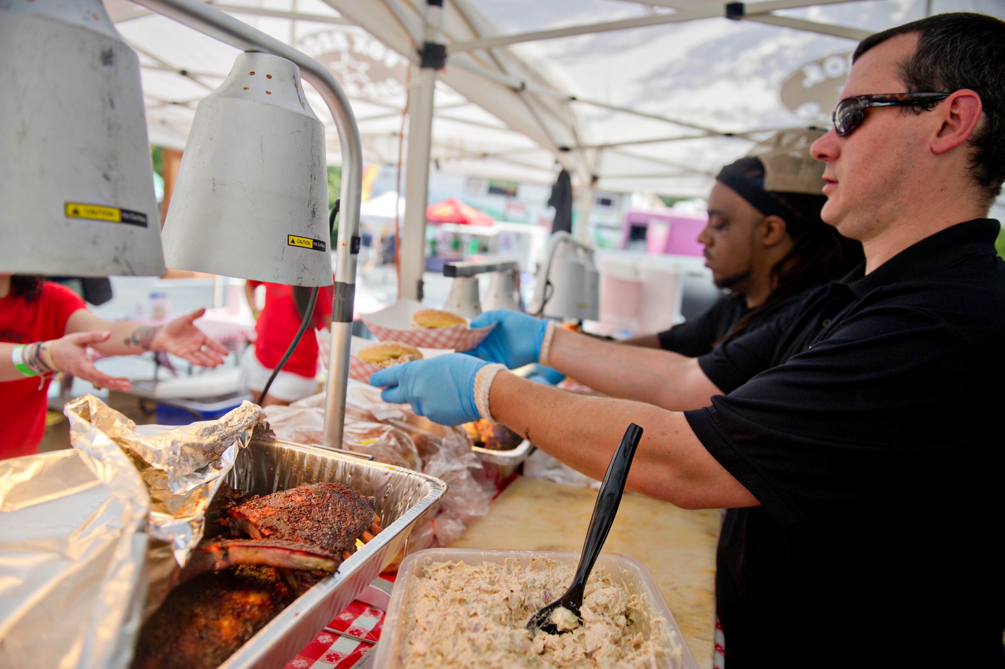 Scott Carlyle fills orders for barbeque during the Decatur BBQ, Blues & Bluegrass Festival at Harmony Park in Decatur on Saturday, August 16, 2014. The 14th annual festival featured over seven hours of blues and bluegrass performances as well as beer, barbeque and children's activities.