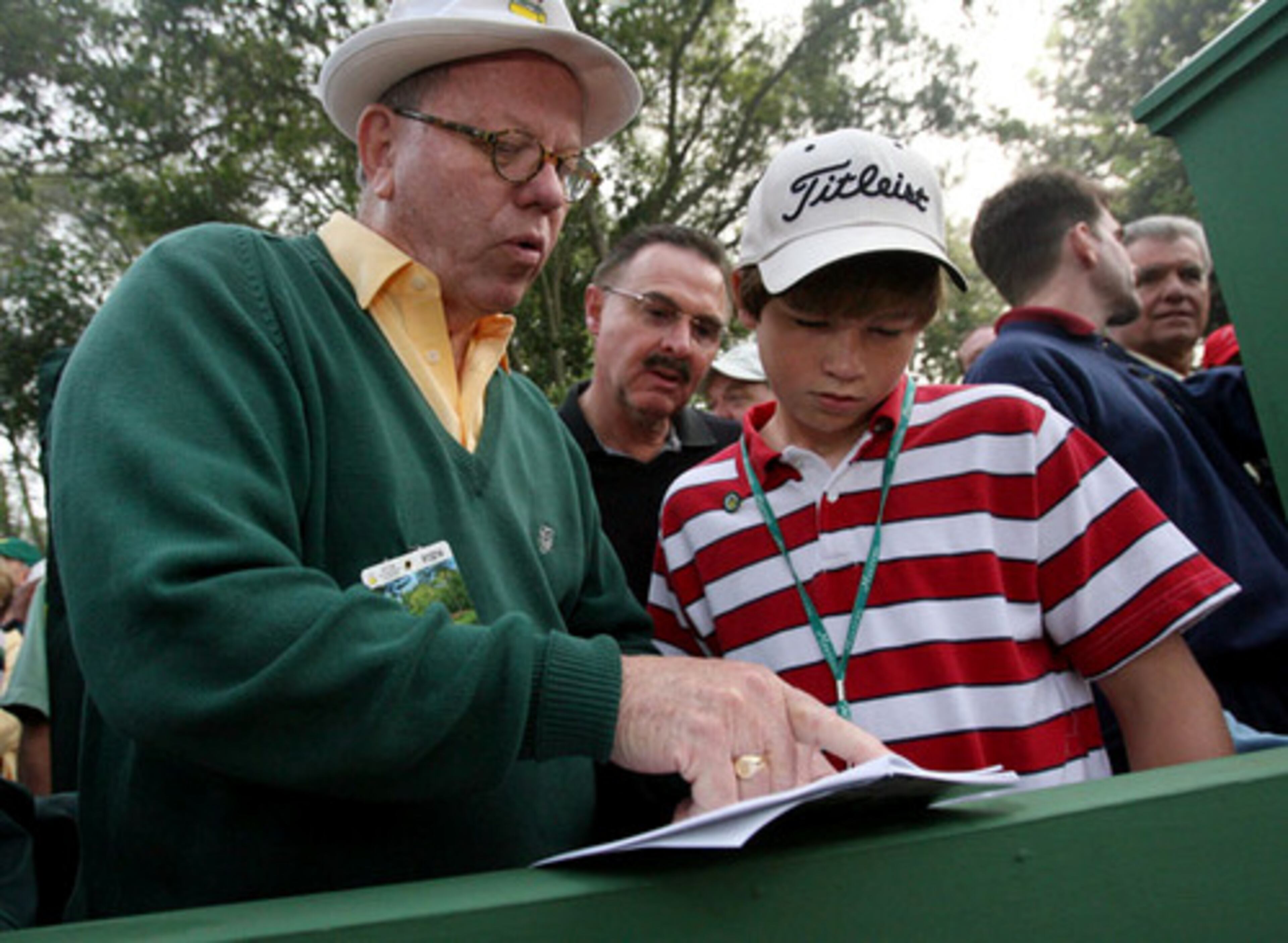 Viewing the Masters has its own strategy, too. William Parks, of Chapel Hill, N.C., (left) browses the spectator guide with William Hall, of Morehead City, N.C., and his son Ty Hall, 13, right.