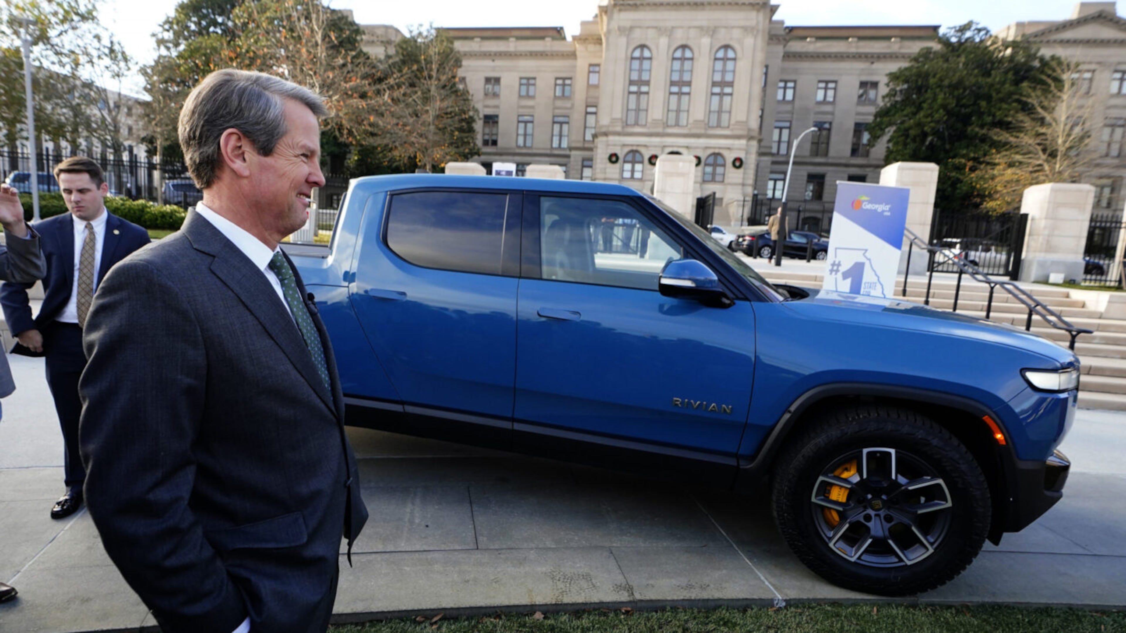 FILE - In Atlanta, Republican Gov. Brian Kemp stands next to a Rivian electric truck while announcing the company's plans to build a plant east of Atlanta, Dec. 16, 2021. (John Bazemore/AP)